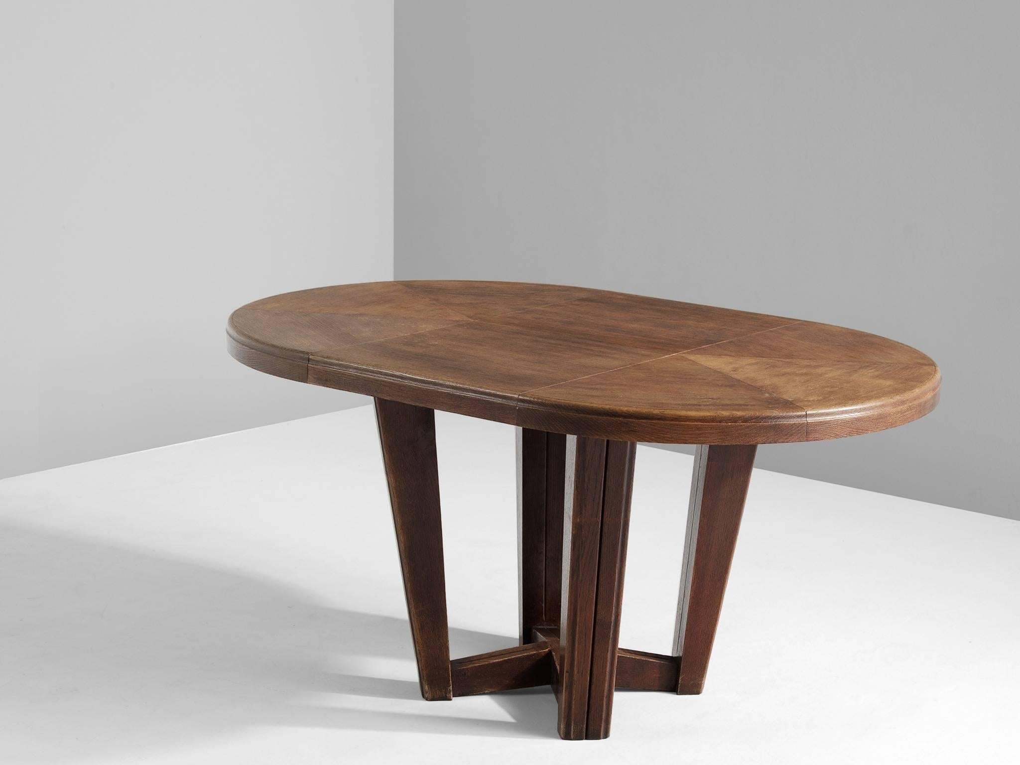 Dining table, in oak, France, 1930s. 

Small oval dining table with inlaid top. This elegant art-deco table has an interesting base. The four tapered legs are combined with a cross-connection. The oval top shows some interesting graphic forms. The