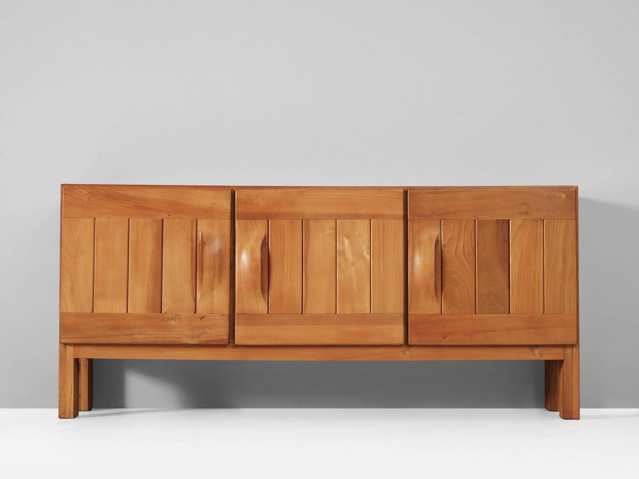 Sideboard, in elm, France, 1960s.

Interesting credenza in elmwood with great details. All tough it's simplistic appearance, this sideboard was made with high attention to detail and respect for the material. The three doors show an interesting