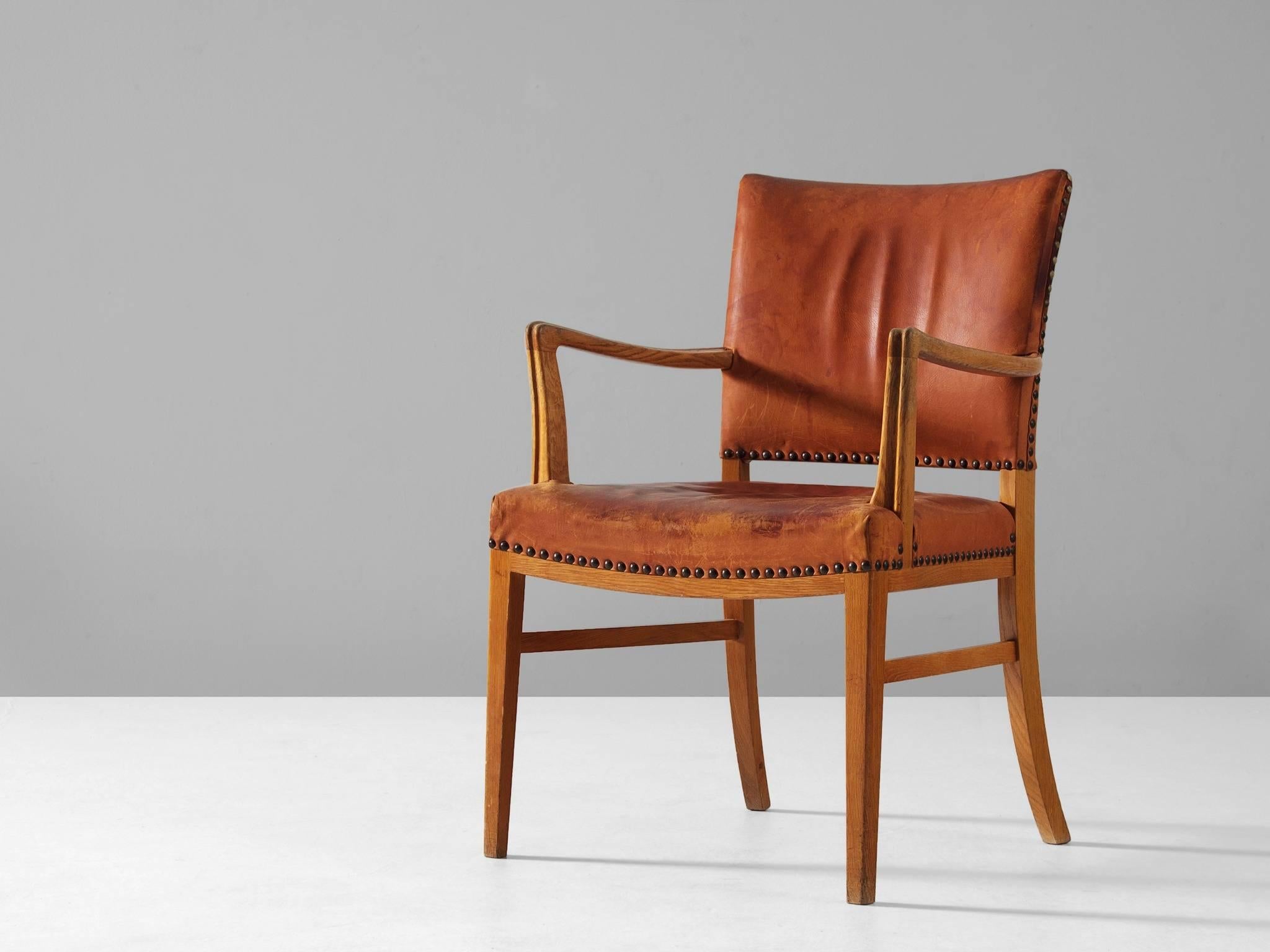 Armchair, in leather and oak, Denmark, 1940s. 

Refined and elegant armchair. This piece echoes the classical style of the 18th century in combination with Scandinavian Modernism. The armchair consist of a solid oak frame. The legs are slightly