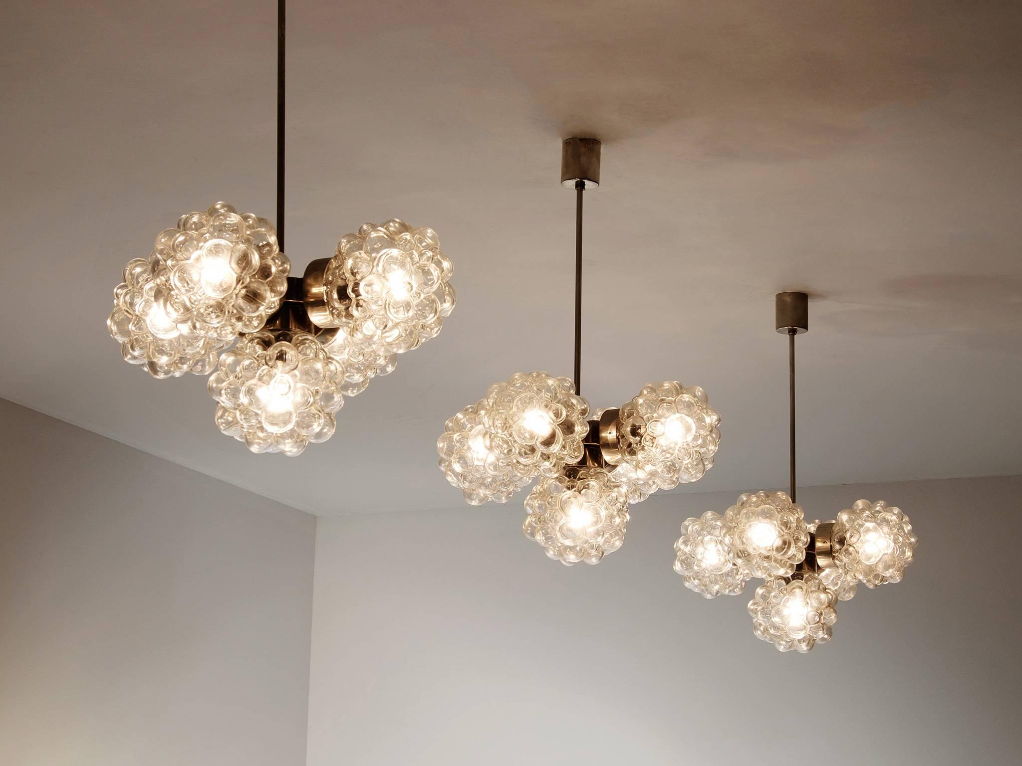 Set of 8 pendants, in metal and glass, designed by Helena Tynell, Europe, 1970s. 

Large set of structured glass chandeliers. Each light has five spheres, which makes sure the light gets nicely divided over the room. The structured glass creates an