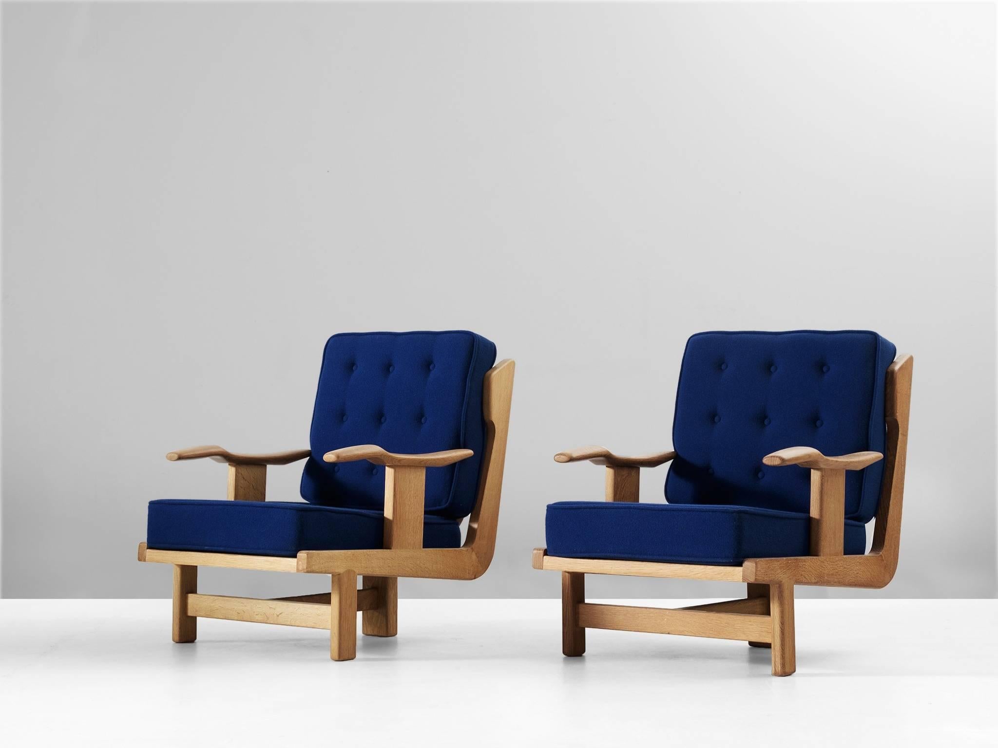 Lounge chairs, in oak and fabric, by Guillerme et Chambron, France, 1960s.

Sculptural pair of lounge chairs in solid oak. The frame of these chairs is highly detailed. The base consist of three legs, which emphasizes the back. The armrest are