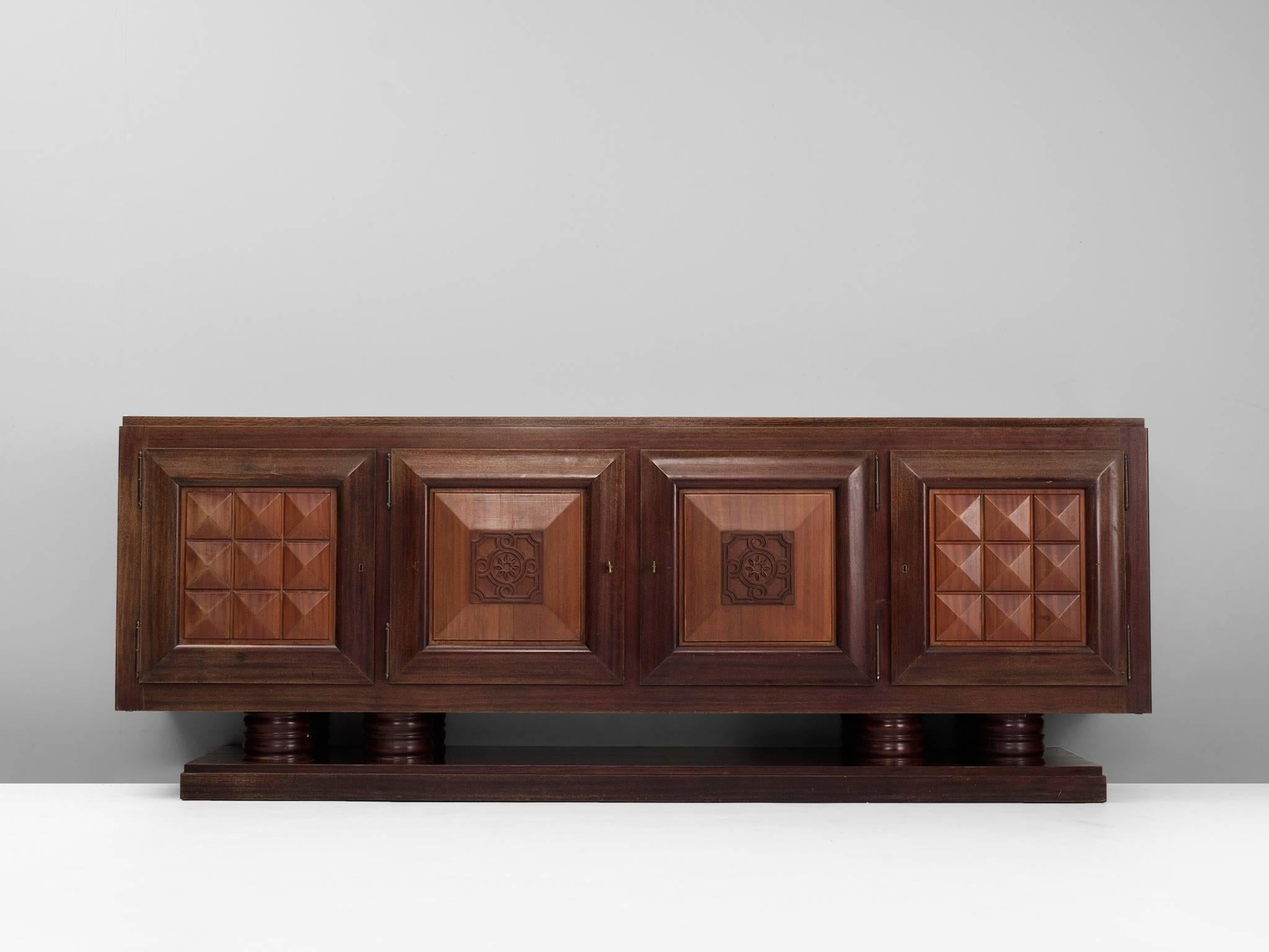 Credenza, in cedar/mahogany, by Gaston Poisson, France, 1930s. 

Sturdy credenza in oak with graphical door panels and parquet top. This four-door sideboard is equipped with several shelves and drawers which provide plenty of storage space. The