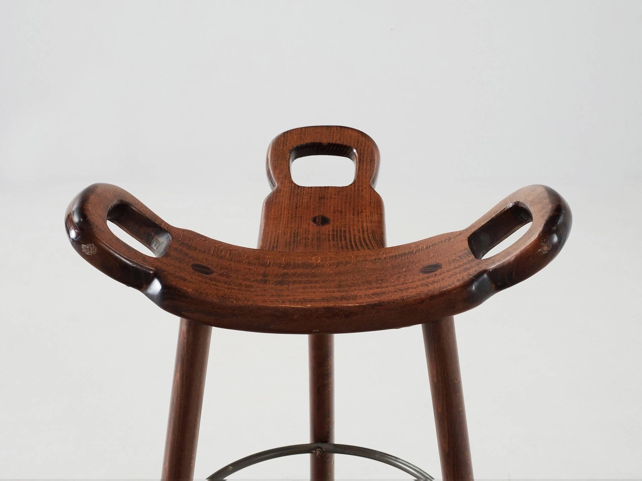 Set of eight 'Brutalist' or 'Marbella' bar stools, in stained beech and metal, Spain 1970s. 

Set of eight Brutalist bar stools in dark-brown stained beech. The eye-catching part is the seating. A curved T-shape with three handles. The handles are