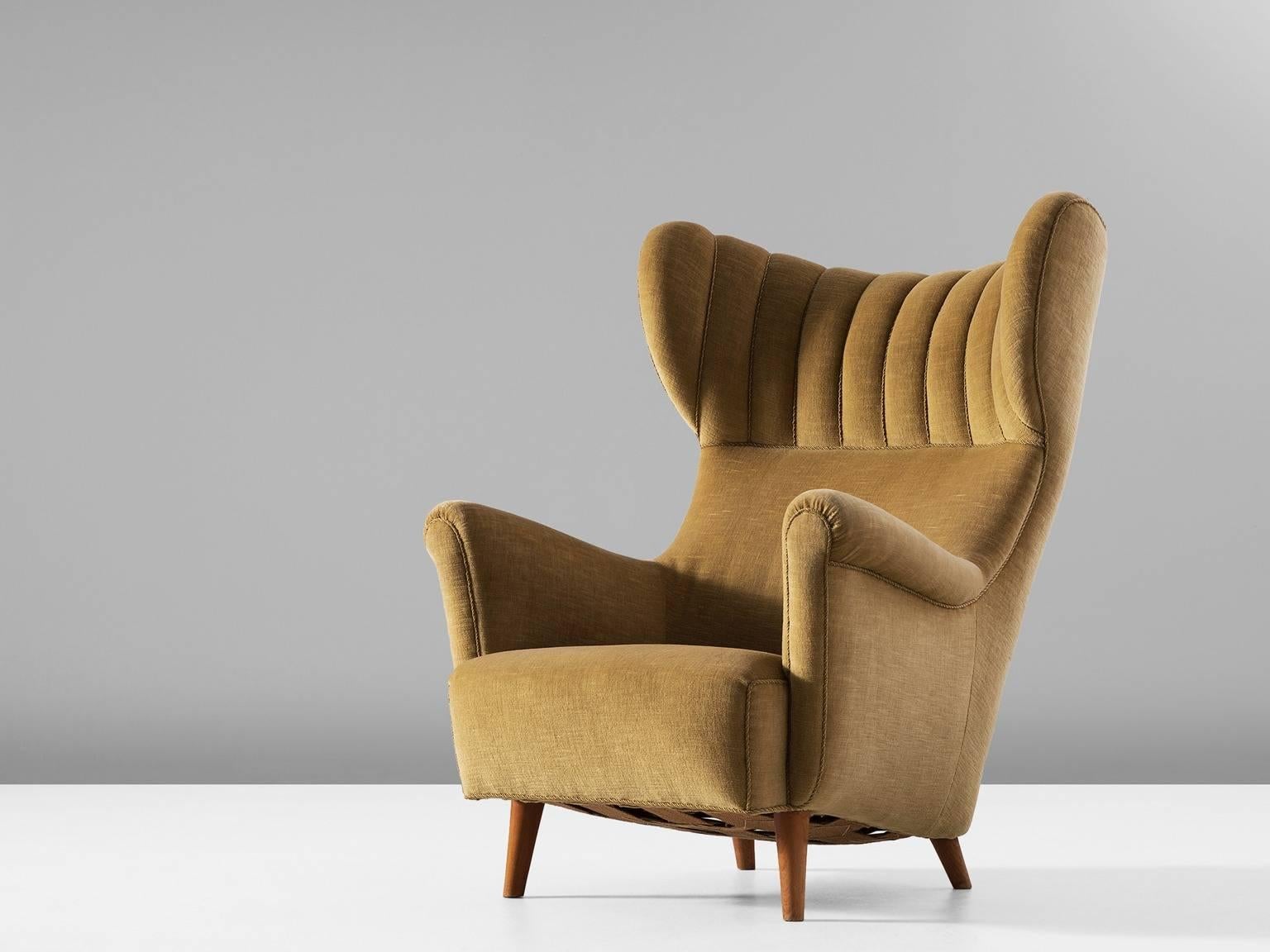 Wingback chair, in fabric and wood, Italy, 1960s. 

Large armchair in off-white/crème mohair. The eye-catching detail is the large padded wingback. Besides this, the armrest are also very elegant. The tight outside is a nice contrast to the more