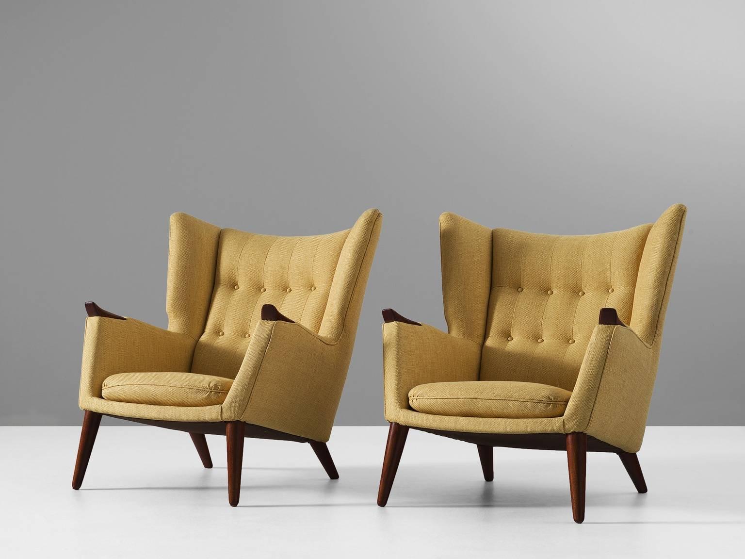 Pair of lounge chairs, in teak and fabric, by Kurt Østervig, Denmark 1960s. 

Highly comfortable pair of lounge chairs with clear traits of the Danish modern style. This royal design by Ostervig has a more solid and closed character. The high back