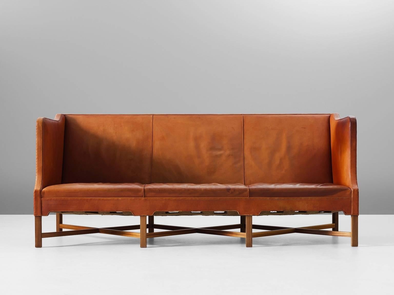 Kaare Klint for Rud Rasmussen, sofa model 4118, in leather and mahogany, by Denmark 1929.

Classic and elegant Scandinavian three-seat sofa by Kaare Klint. This model was designed in 1929. The base consist of eight legs in mahogany with X-shaped