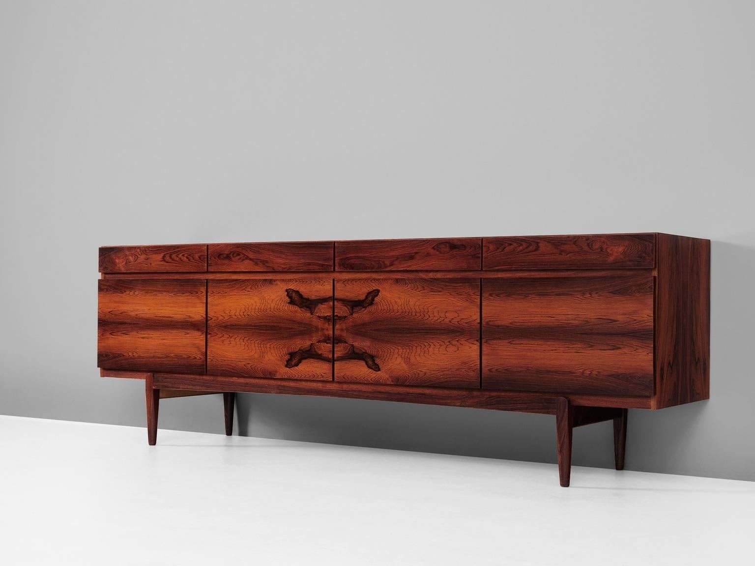 Sideboard model FA-66, in rosewood, by Ib Kofod-Larsen for Faarup Møbelfabrik, Denmark. 
 
Excellent designed rosewood credenza by Ib Kofod-Larsen. The sideboard contains four doors with four drawers directly above it. The inside contains three