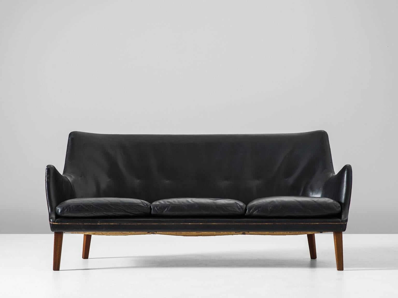 Sofa, in leather and wood, by Arne Vodder for Ivan Schlechter, Denmark 1953.

Elegant three-seat sofa in black leather by Danish designer Arne Vodder. This sofa shows the great craftsmanship of Arne Vodder. The seating and back show a nice organic