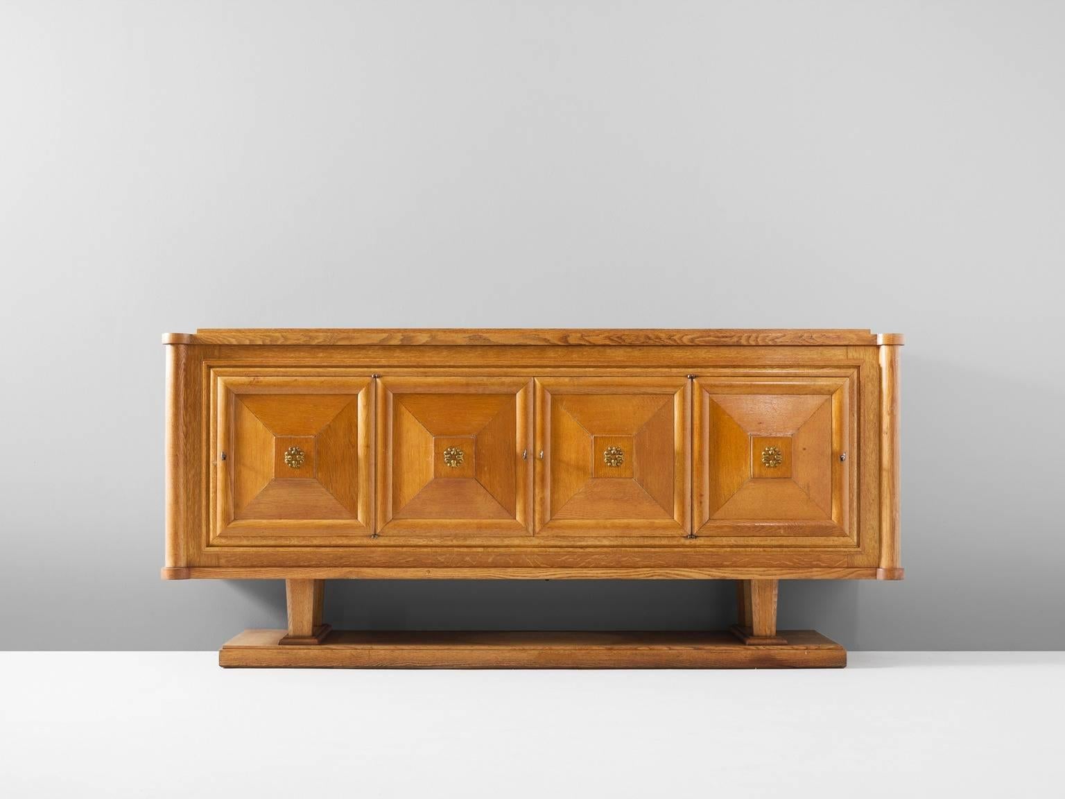 Credenza, in oak and brass, France, 1930s. 

Wide credenza in oak with brass details. Four doors, all with beautifully designed wooden graphical patterns. The diagonal lines with added squares and a frame emphasize the three-dimensional character