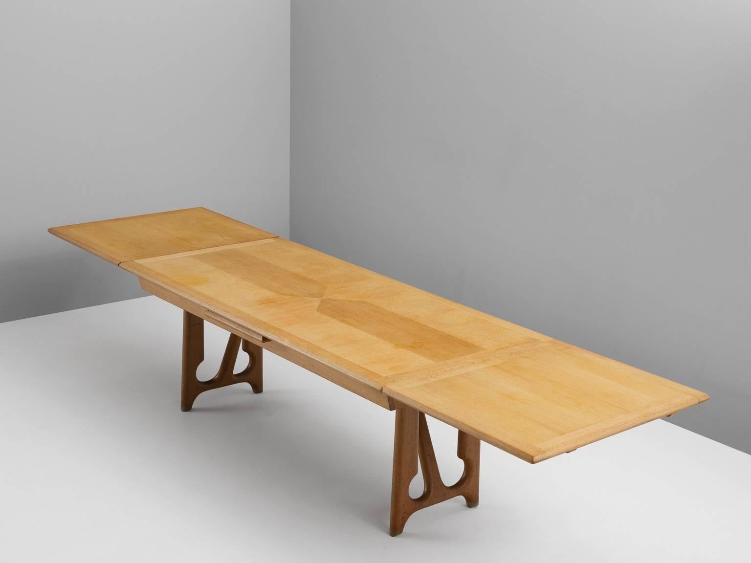 Dining table, in oak, by Guillerme & Chambron, France 1965. 

Extendable dining table in solid oak by French designers Guillerme et Chambron. This elegant table shows interesting details. Most attractive is the inlayed top. These graphical