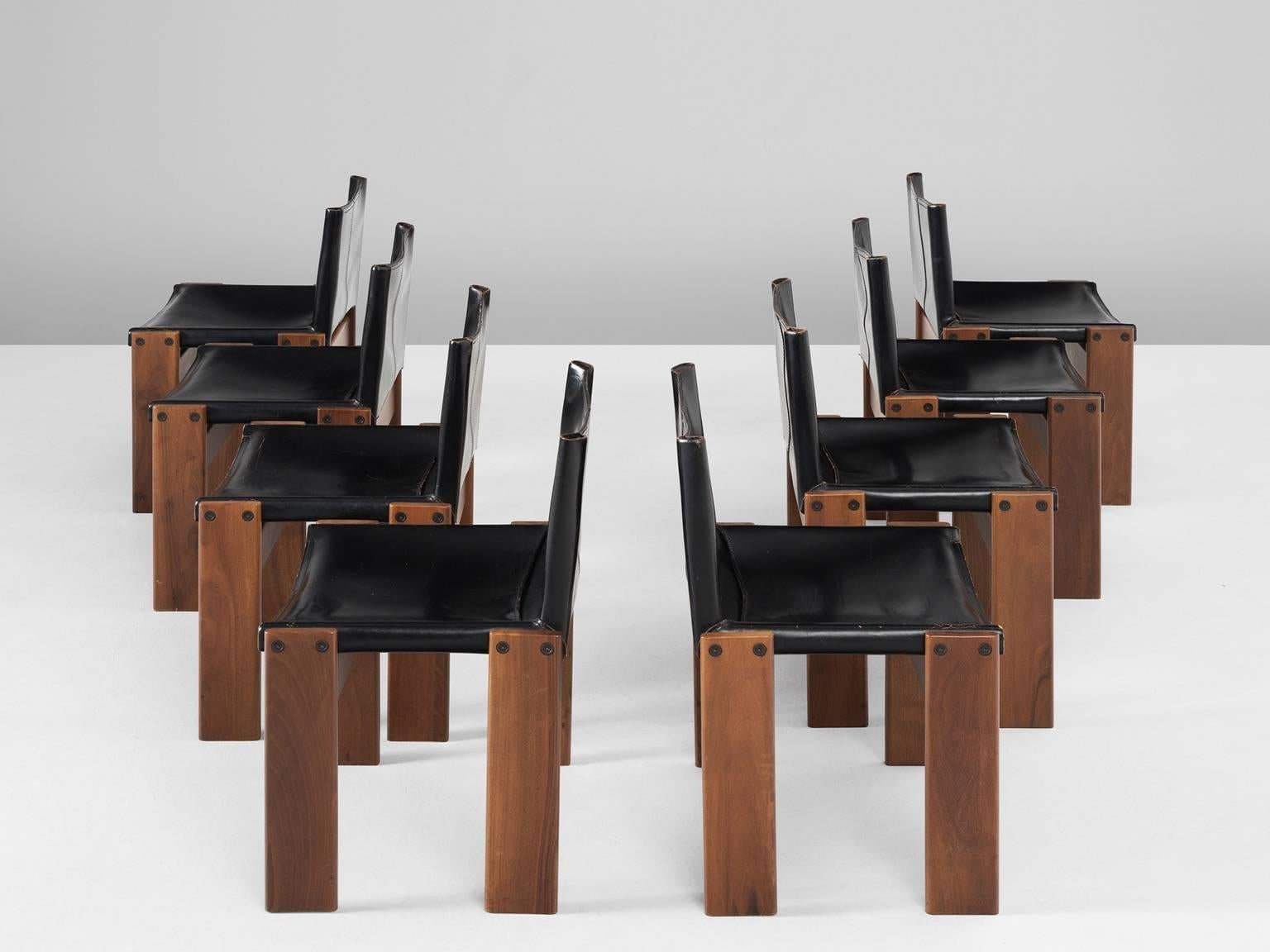 Set of eight 'Monk' dining chairs in leather and teak, by Afra & Tobia Scarpa for Molteni, Italy, 1974. 

Chairs with a frame of teak. Four wide legs which gives these chairs a cubic appearance. The seating and back are from black colored leather,