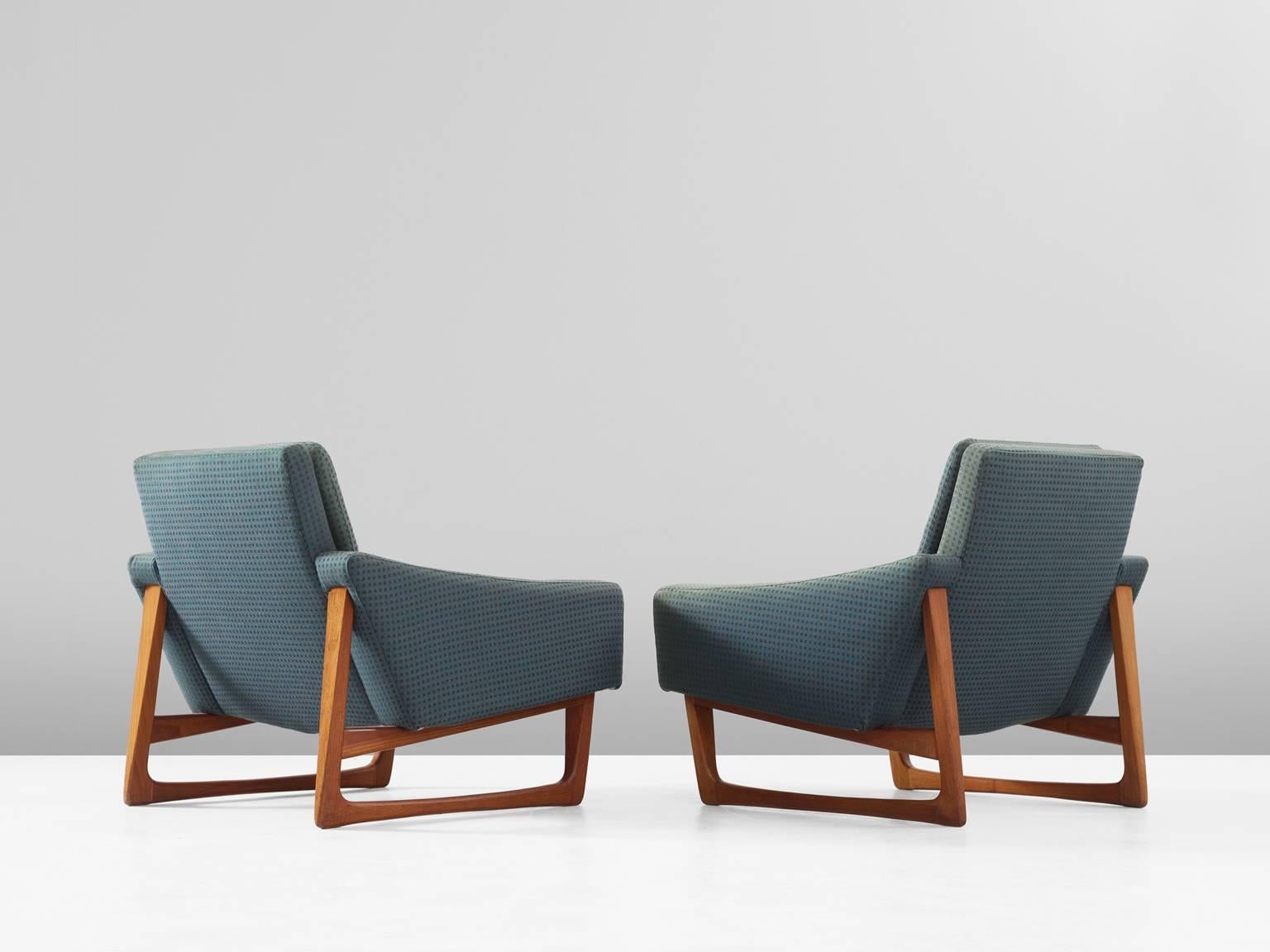 Set of two lounge chairs, in teak and fabric, Scandinavia, 1960s. 

Pair of easy chairs with beautiful detailed teak frame. The frame has characteristic sled legs with rounded edges and diagonal cross connections. By their high and open legs, the