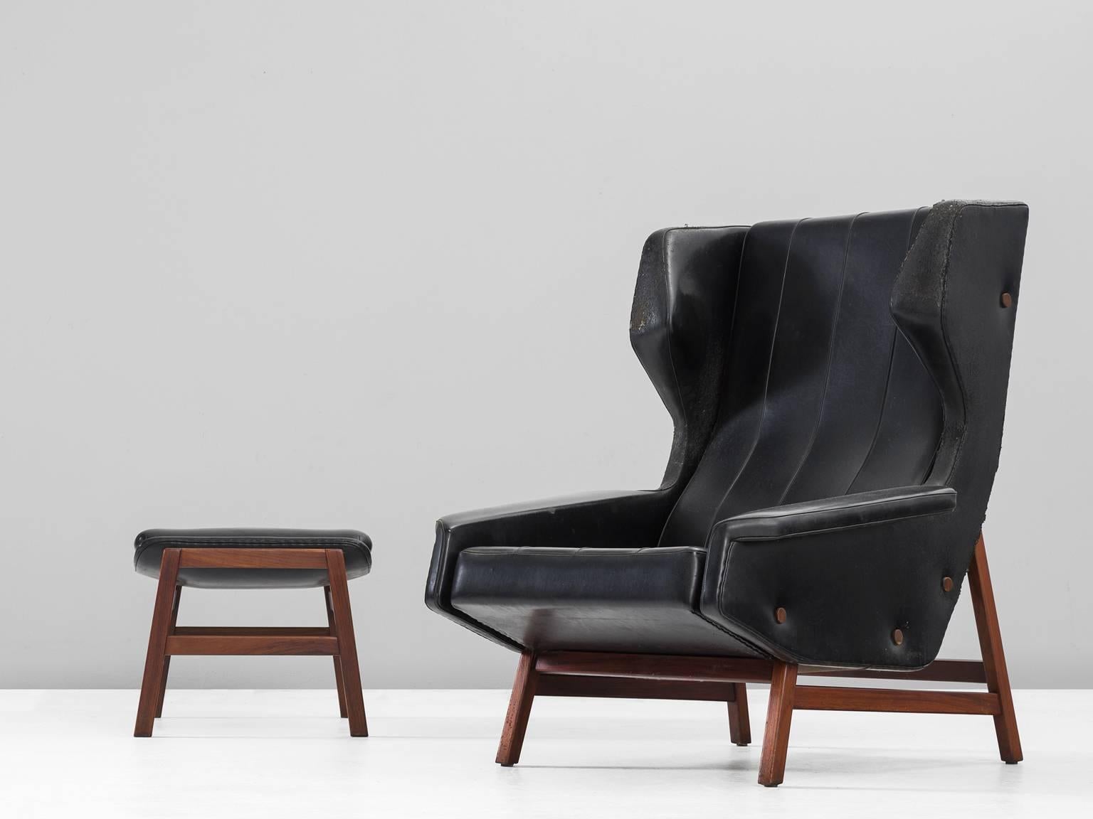 Gianfranco Frattini, model 877, made by Cassina 1959
Lounge chair, in faux-leather and wood, Italy, 1950s. 

Sturdy and voluminous lounge chair in black skai-leather. This wingback chair shows nice details and elegant lines. The buttons on the