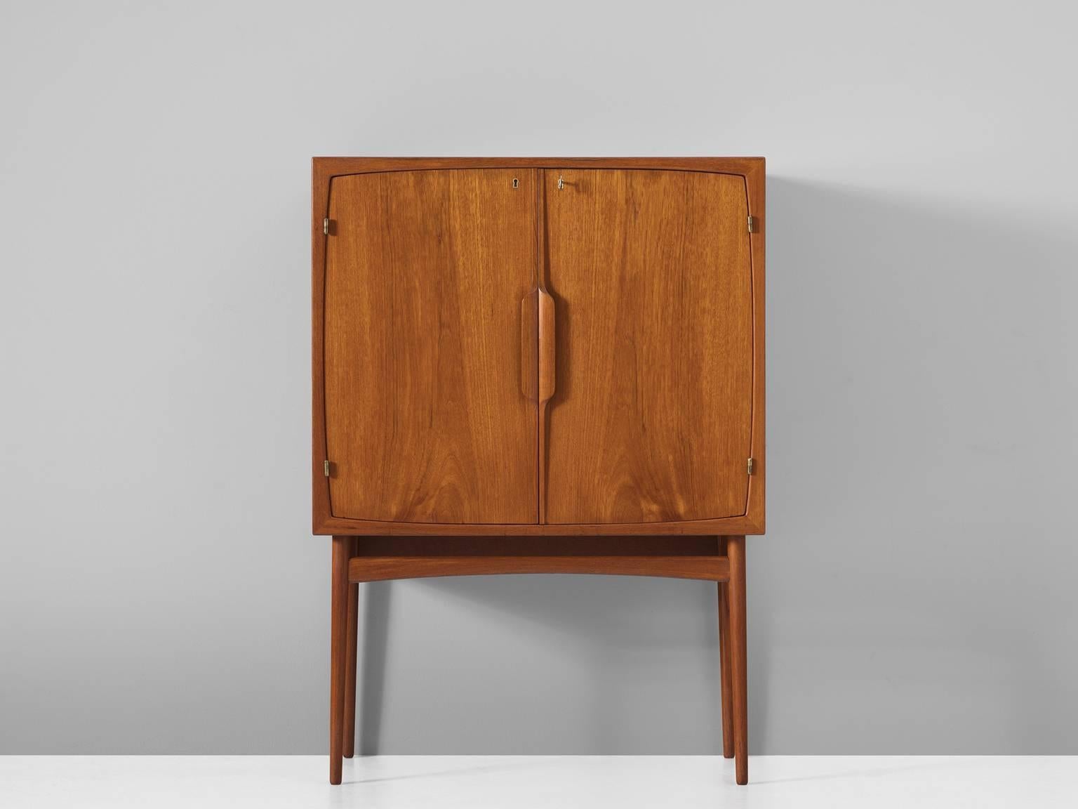 Dry bar model Bacchus, in teak, glass and brass, by Torbjorn Afdal for Mellemstrands MøbelfabrikNorway, 1950s.

This well preserved small bar cabinet is a beautiful example of Scandinavian craftsmanship. The design is basic yet refined. The bar