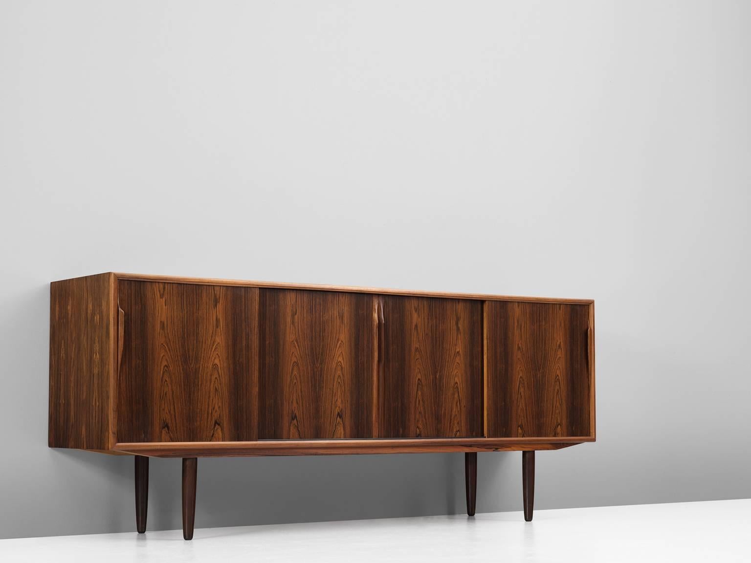 Sideboard, in rosewood, Denmark, 1960s.

This highly refined credenza has a modest and well proportioned design, showing extraordinary rosewood veneer. The four sliding doors have an interesting mirrored pattern of a lively grain. The contrasting