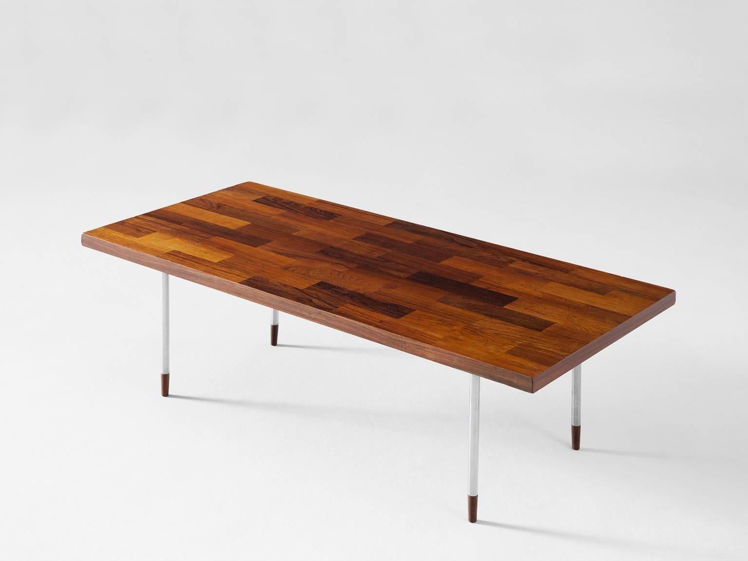Rectangular coffee table, in rosewood and stainless steel, Denmark 1960s.

The rectangular top is made with rosewood veneer slats, in wonderful different tones. The warm expression of the basic top beautifully contrasts to the thin tubular steel