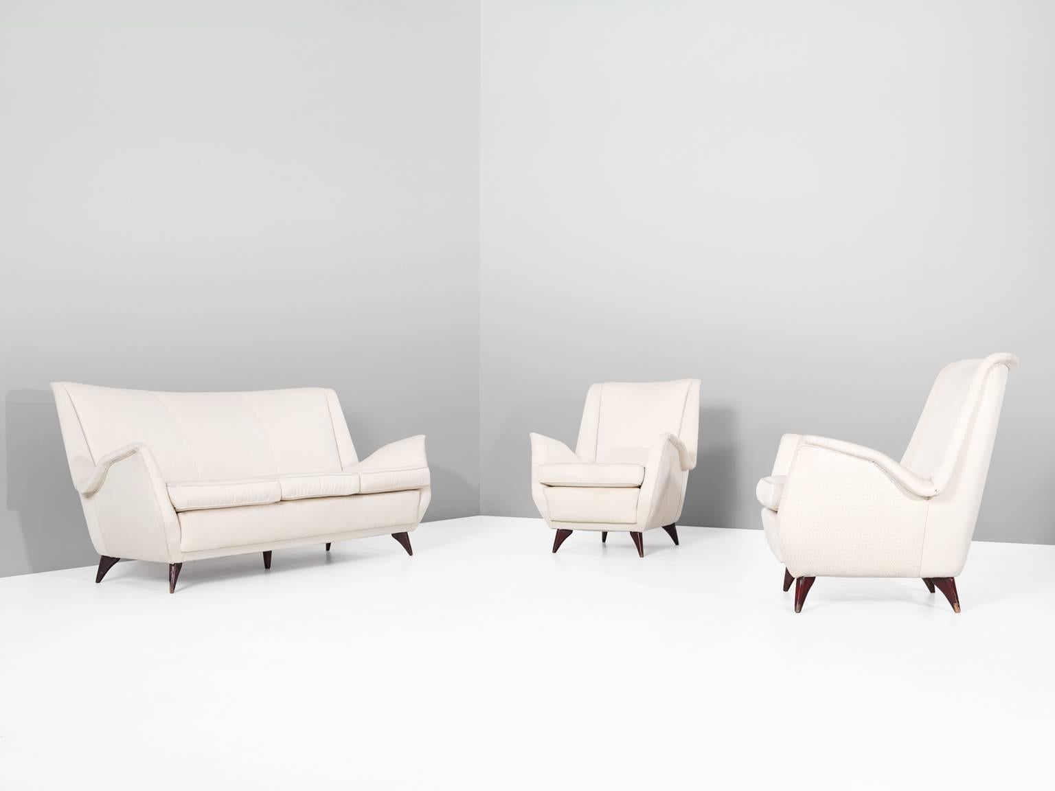 Living room set, in wood and fabric, Italy, 1950s.

Italian living room set in off-white pattern fabric. These items show beautiful and elegant lines. The wide seating is accomplished with nicely folded armrests. The dark stained wooden legs makes
