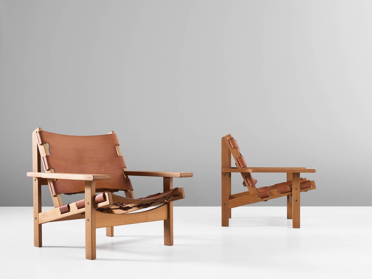 Pair of armchairs, in oak and leather, by Erling Jessen, Denmark, 1960s. 

Stunning pair of 'Jagt Stolen' by Erling Jessen, who was inspired by Børge Mogensens Spanish chair. The frame consist of solid oak and makes a sturdy appearance. The