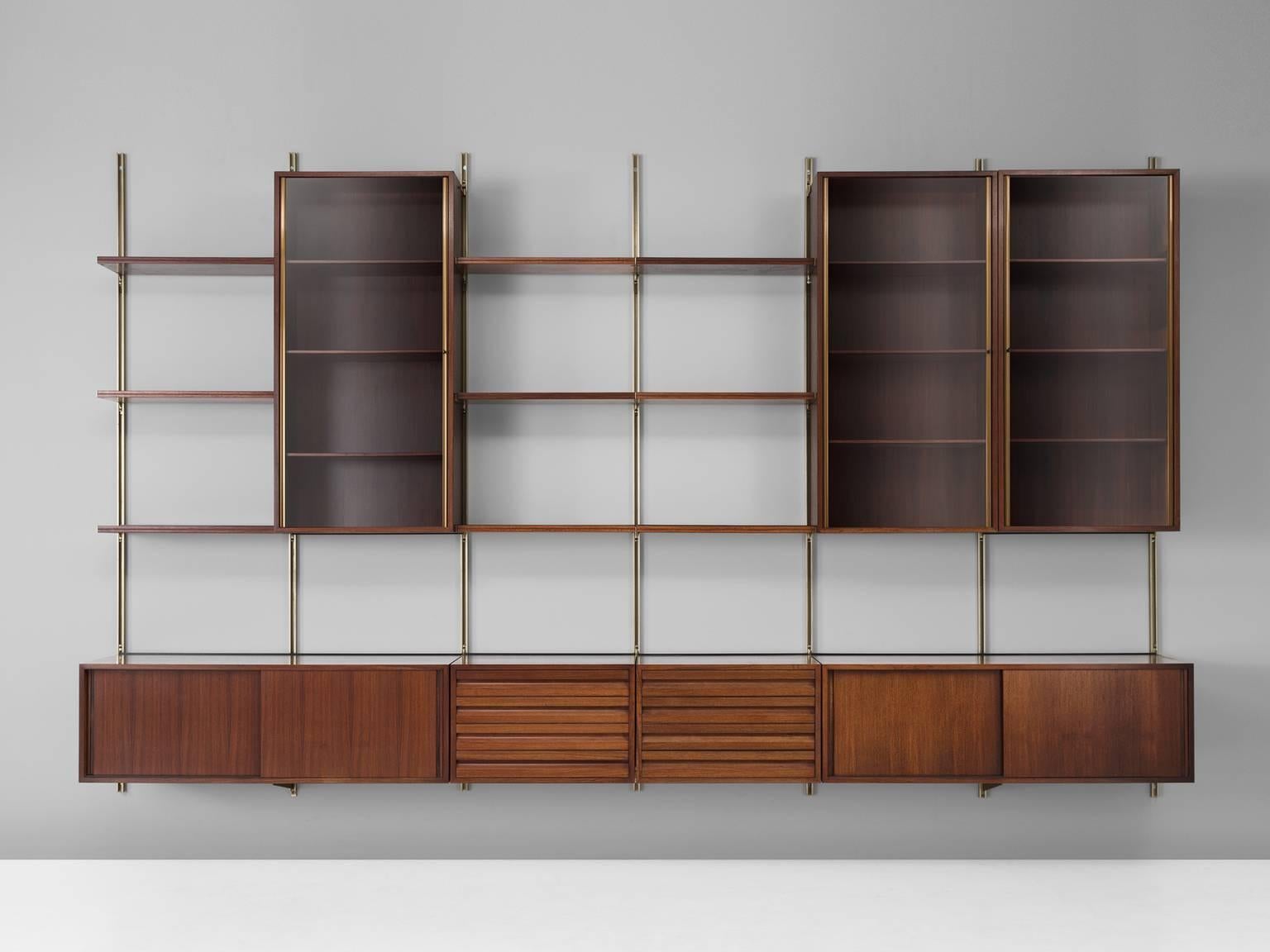 E22 wall-unit, in metal, brass, smoked glass and rosewood, by Osvaldo Borsani for Tecno, Italy, 1957.

This system of shelves was developed by the combination of the earlier L60 bookcase and the A57 wardrobe. According to Osvaldo Borsani the home