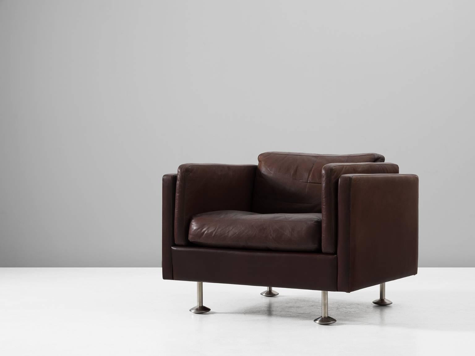 Lounge chairs, in leather and stainless steel, by Illum Wikkelsø, Denmark, 1960s. 

Easy chair in dark brown leather, by Danish designer Illum Wikkelsø. This club chair has a cubic design. The tight and clean outside is complemented with a soft and
