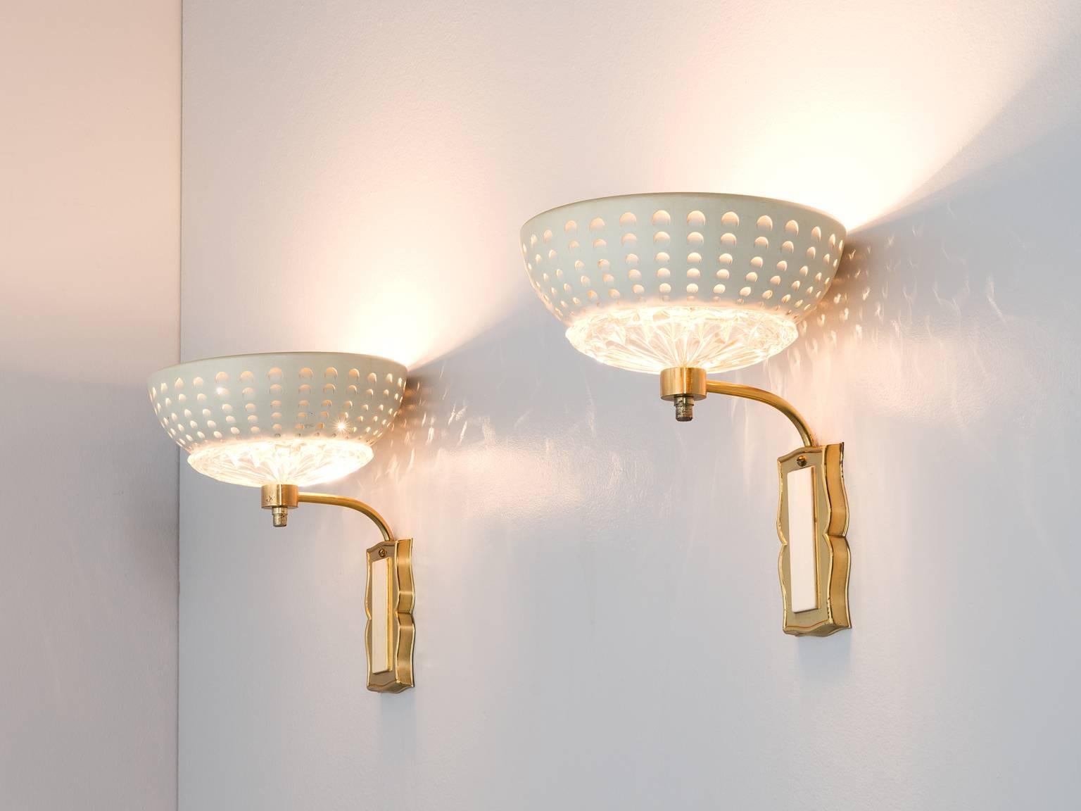 Pair of wall lights, in brass, glass and metal, Europe, 1970s. 

Elegant pair of wall lights in brass. The brass fixture holds an arch on which the bowl shaped lights are mounted. Each light consist of a small structured glass scale, with on top a