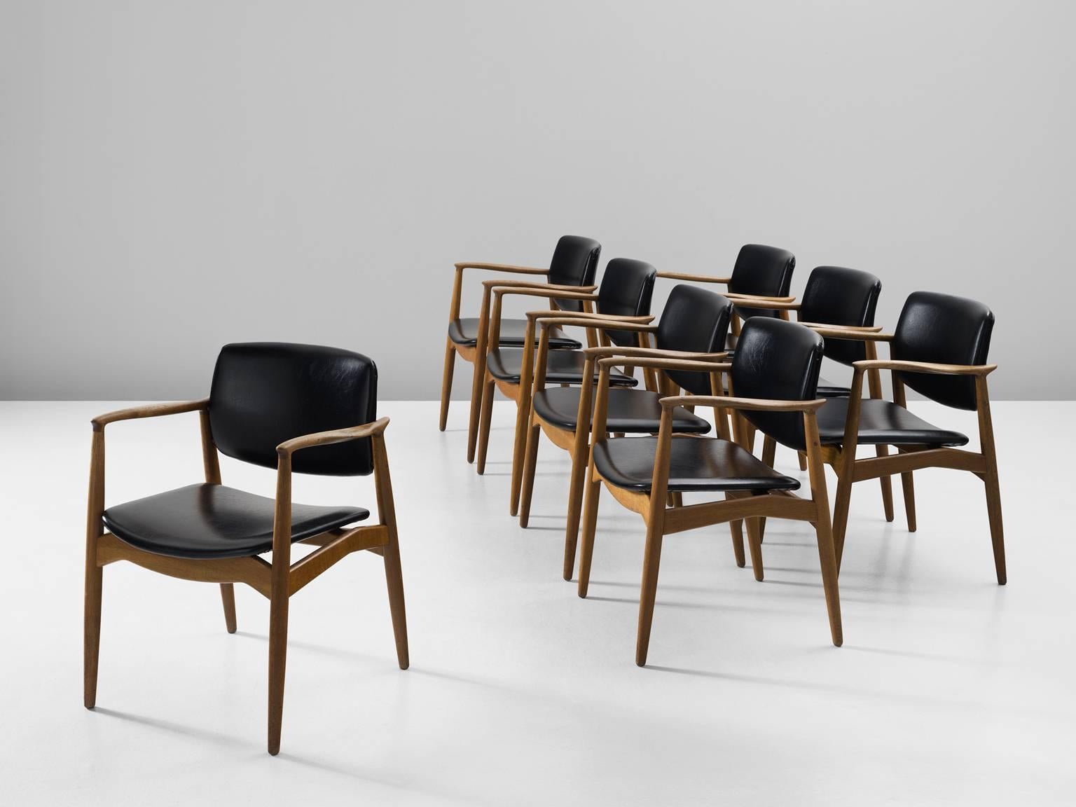 Set of eight 'Captains' armchairs, in oak and faux-leather by Erik Buck for Ørum Møbler, Denmark, 1957. 

Set of eight sculpted dining chairs in solid oak. These chairs show the characteristics of the well-known model 50 by Erik Buck. Yet this