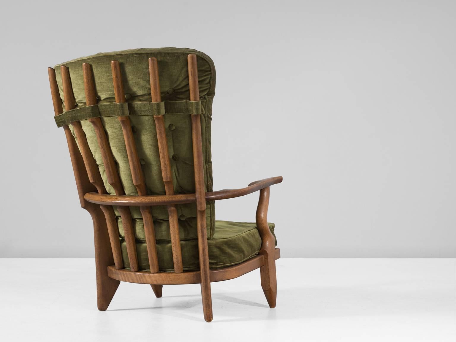 'Grand Repos' lounge chair in oak and fabric, by Guillerme et Chambron, France, 1960. 

High back lounge chair in solid oak with the typical characteristic decorative details at the back and capricious forms of the legs. Very comfortable, great