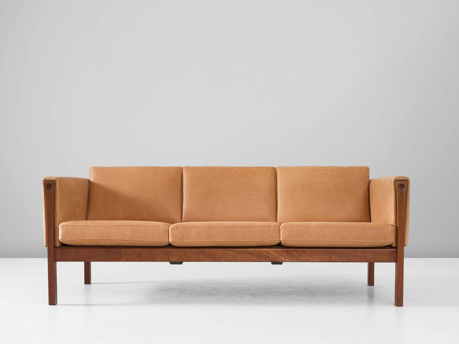 Three-seat sofa model AP62, in black leather and teak, by Hans J. Wegner, Denmark, 1960s. 

Excellent designed sofa by Hans Wegner. The straight lines of this design show an amazing elegance. The teak frame is well proportioned. The way the legs