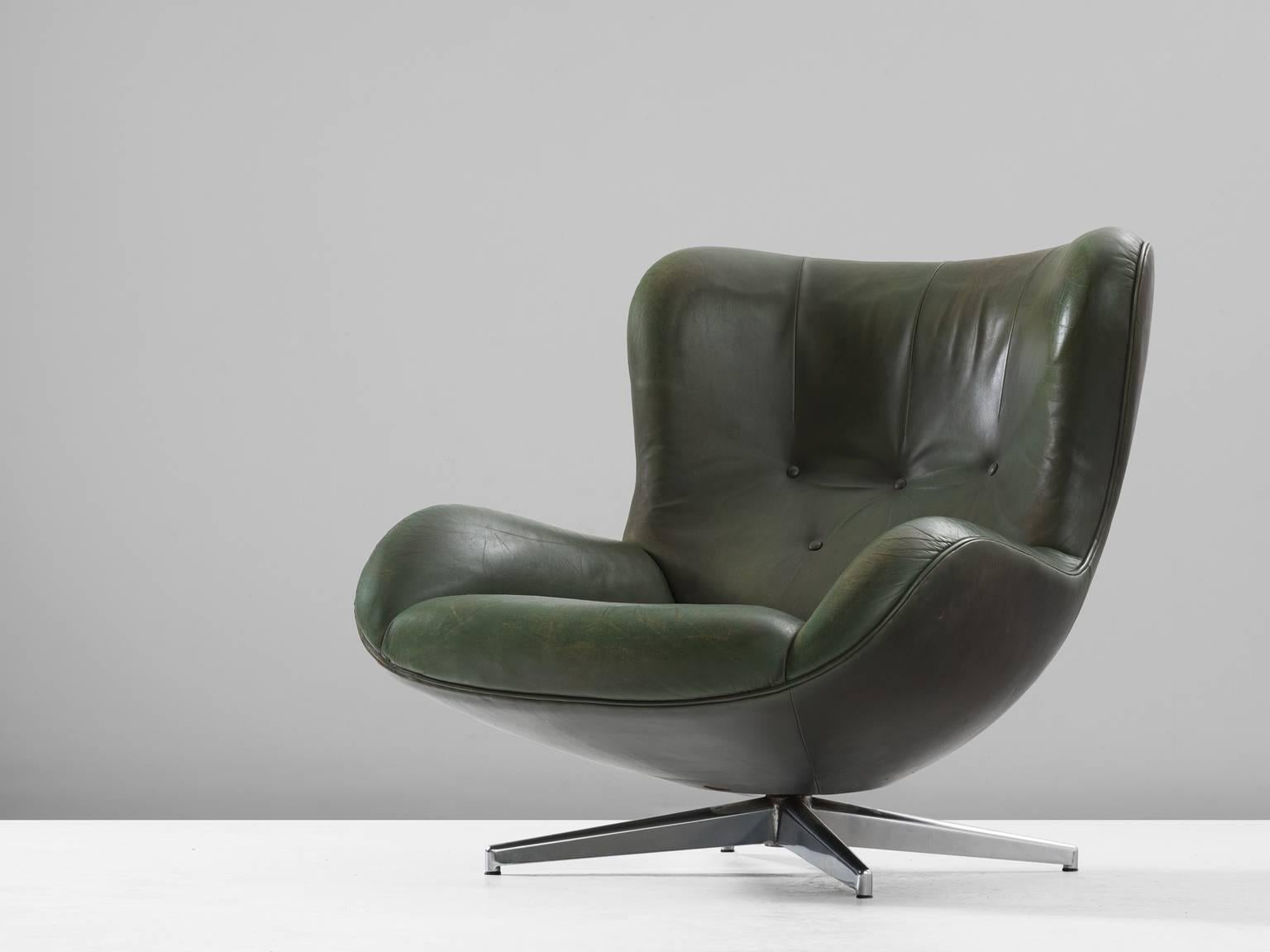 Swivel lounge chair model ML214, in leather and metal, by Illum Wikkelsø, Denmark 1960s.

 Organic shaped easy chair in patinated green leather by Danish designer Illum Wikkelsø. This swivel chair shows some nice contrasts. First the contrasts of