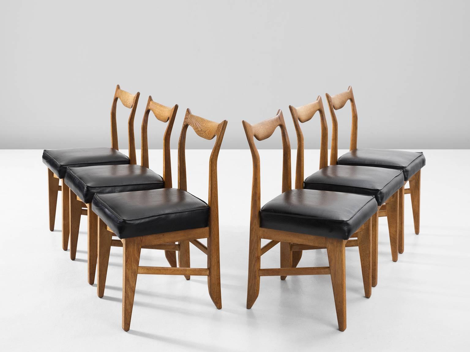 Set of six dining chairs 'Marie Claire', in oak and faux-leather, by Guillerme et Chambron, France, 1960.

Set of six solid oak dining chairs by Guillerme and Chambron. These chairs show the characteristic frame of this French designer duo.