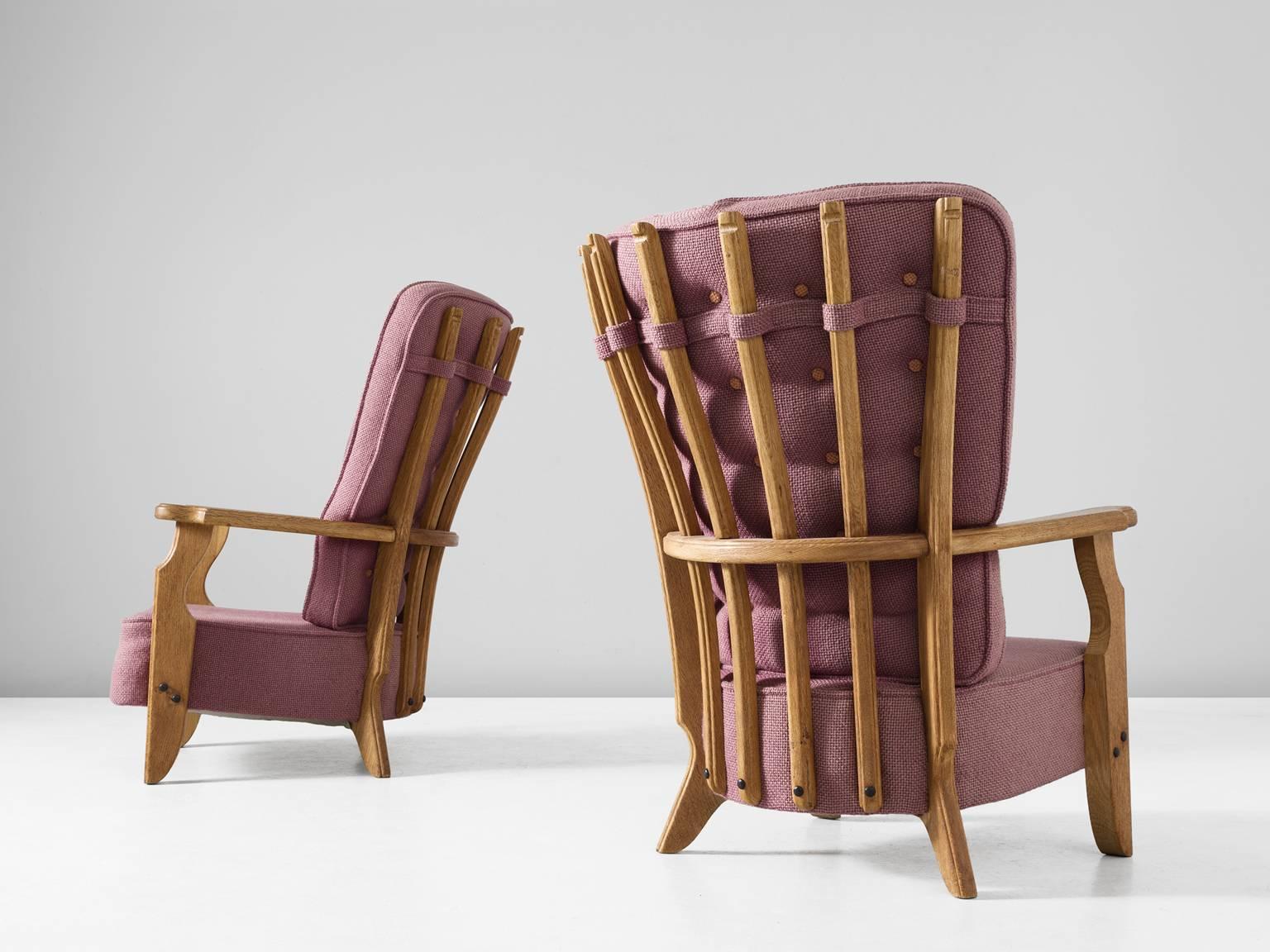 Pair of lounge chairs, in oak and fabric, by Guillerme et Chambron, France 1950. 

High back lounge chairs with in the characteristic style of the French designer duo Guillerme and Chambron. These chairs have a beautiful skeleton back. The legs