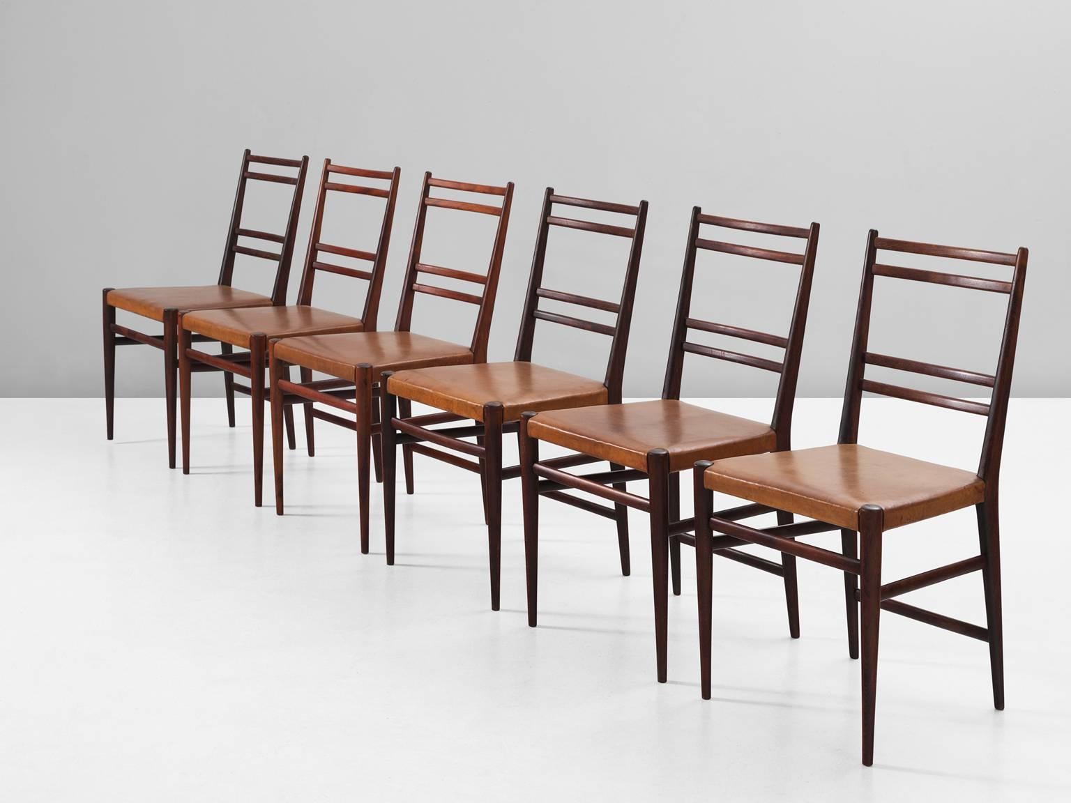 Set of six dining chairs, in beech and leather, Denmark, 1960s. 

Set of six elegant dining room chairs in rosewood colored wood and cognac leather upholstery. These chairs have a beautiful slender frame of stained beech. The legs are cylindrical