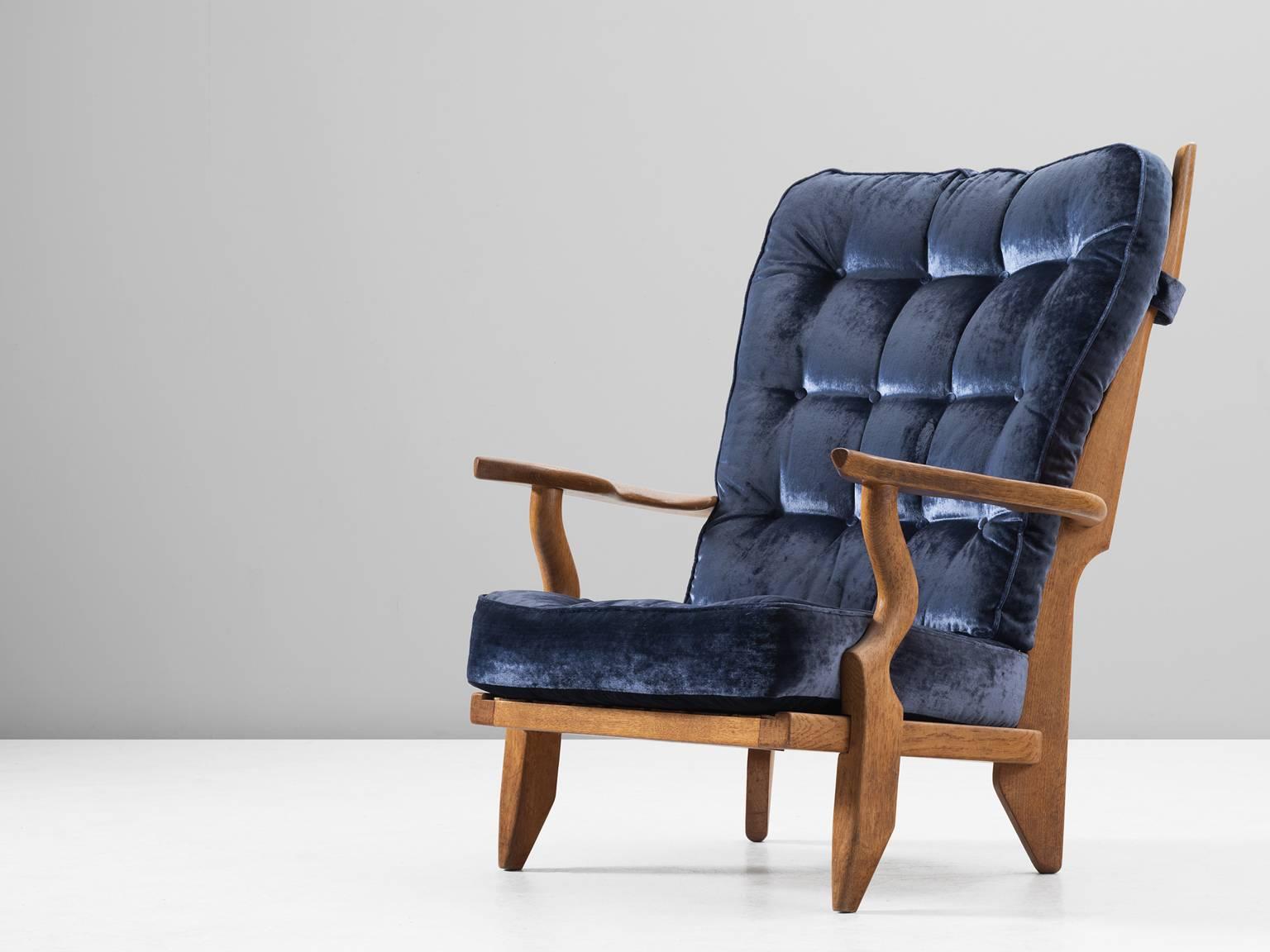 'Grand Repos' lounge chair, in oak and fabric, by Guillerme et Chambron, France 1960.

Extraordinary Guillerme & Chambron high back lounge chair, in solid oak with the typical characteristic decorative details at the back and capricious forms of the