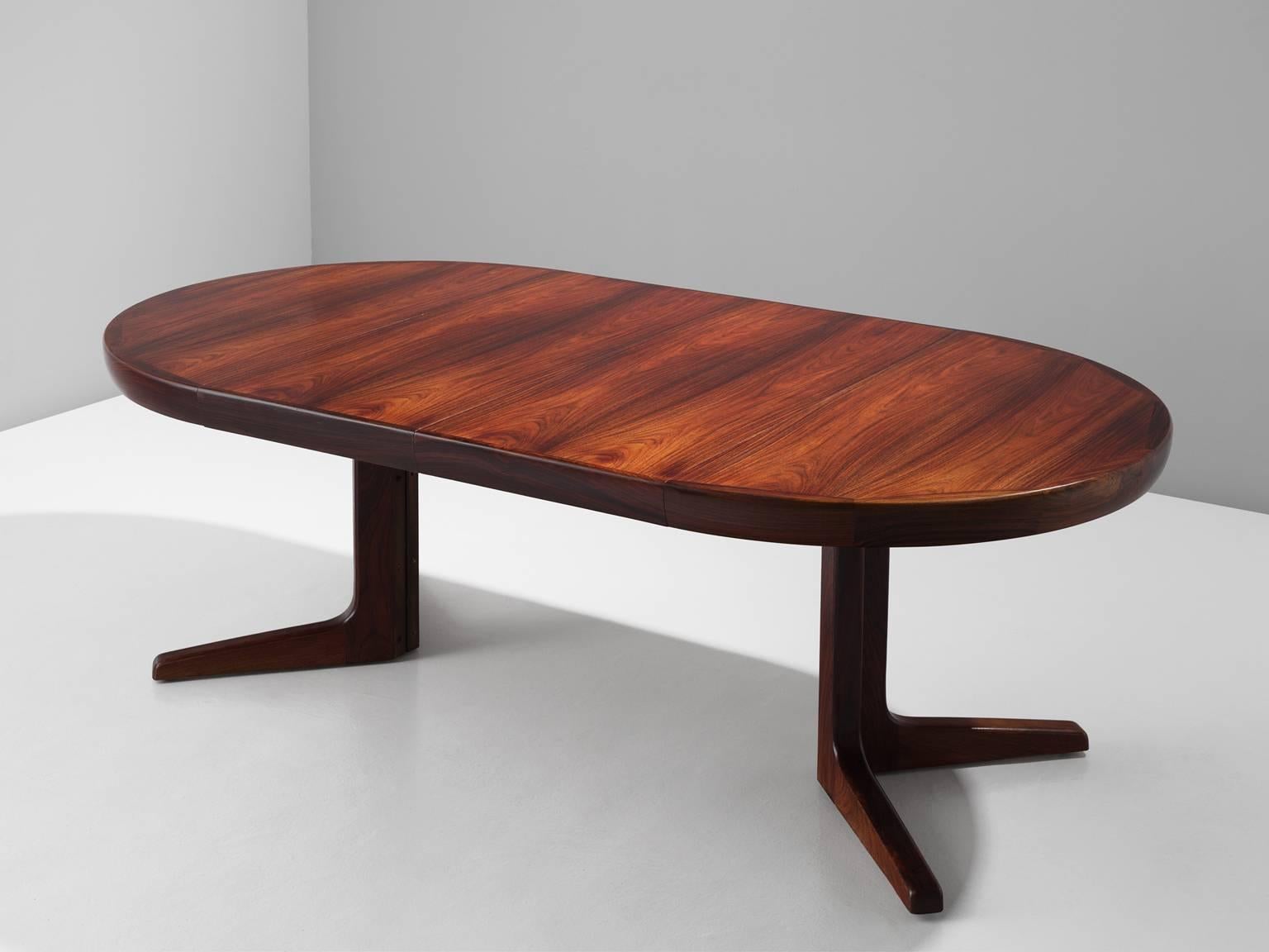 Dining table with two leaves, in rosewood, by Faarup, Denmark, 1960s. 

Elegant extendable dining table in rosewood with two additional leaves. The table has an round tabletop. The two legs together form a diagonal cross. This table is designed in