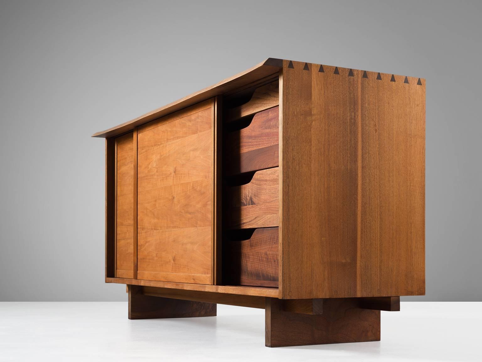 Sideboard in walnut by George Nakashima, United States, circa 1955. 

Cabinet with two sliding doors, executed in walnut with traditional dovetail wood-joints. As a trademark of Nakashima this piece is signed with the client's name on the back of