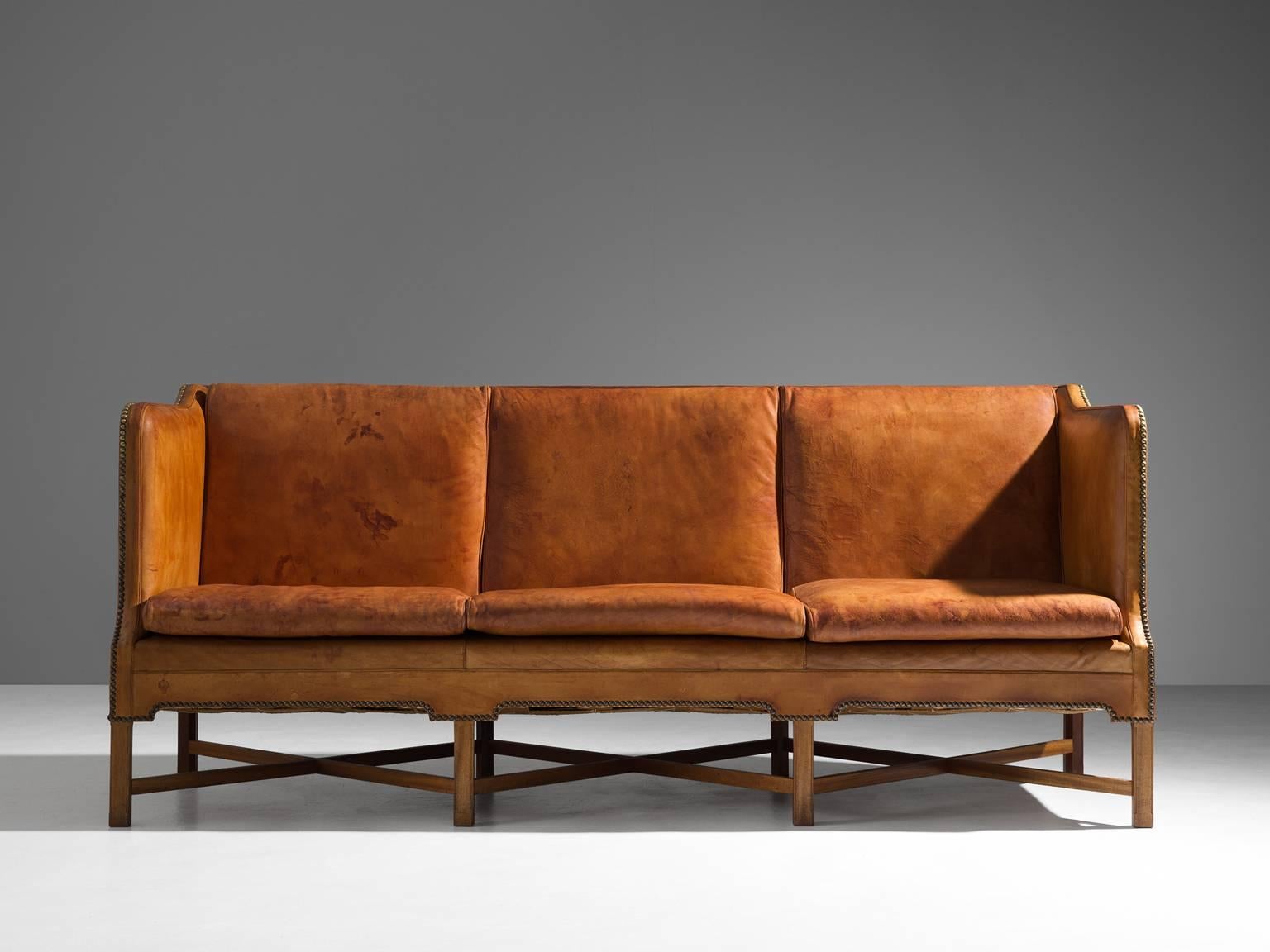 Sofa model 4118, in leather and mahogany, by Kaare Klint for Rud Rasmussen, Denmark 1929. 

Classic and elegant Scandinavian three-seat sofa by Kaare Klint. This model was designed in 1929. The base consists of eight legs in mahogany with X-shaped