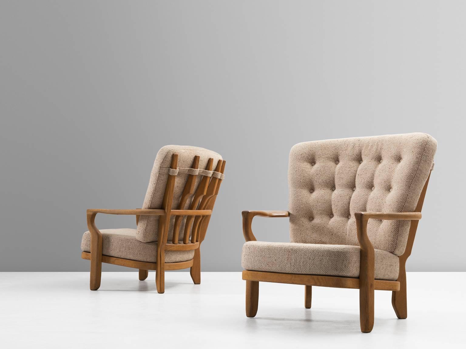 Set of two lounge chairs, in oak and fabric, by Guillerme et Chambron, France, 1960s. 

Set of two extraordinary Guillerme and Chambron armchairs, in solid oak with the typical characteristic decorative details at the back and capricious forms of