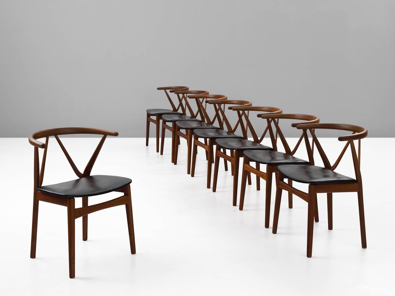 Set of eight dining chairs model 255, in teak and faux-leather by Henning Kjaernulf for Bruno Hansen, Denmark, 1950s. 

Set of eight elegant dining chairs with strong resemblance to the designs of Hans Wegner. These solid teak chairs have a