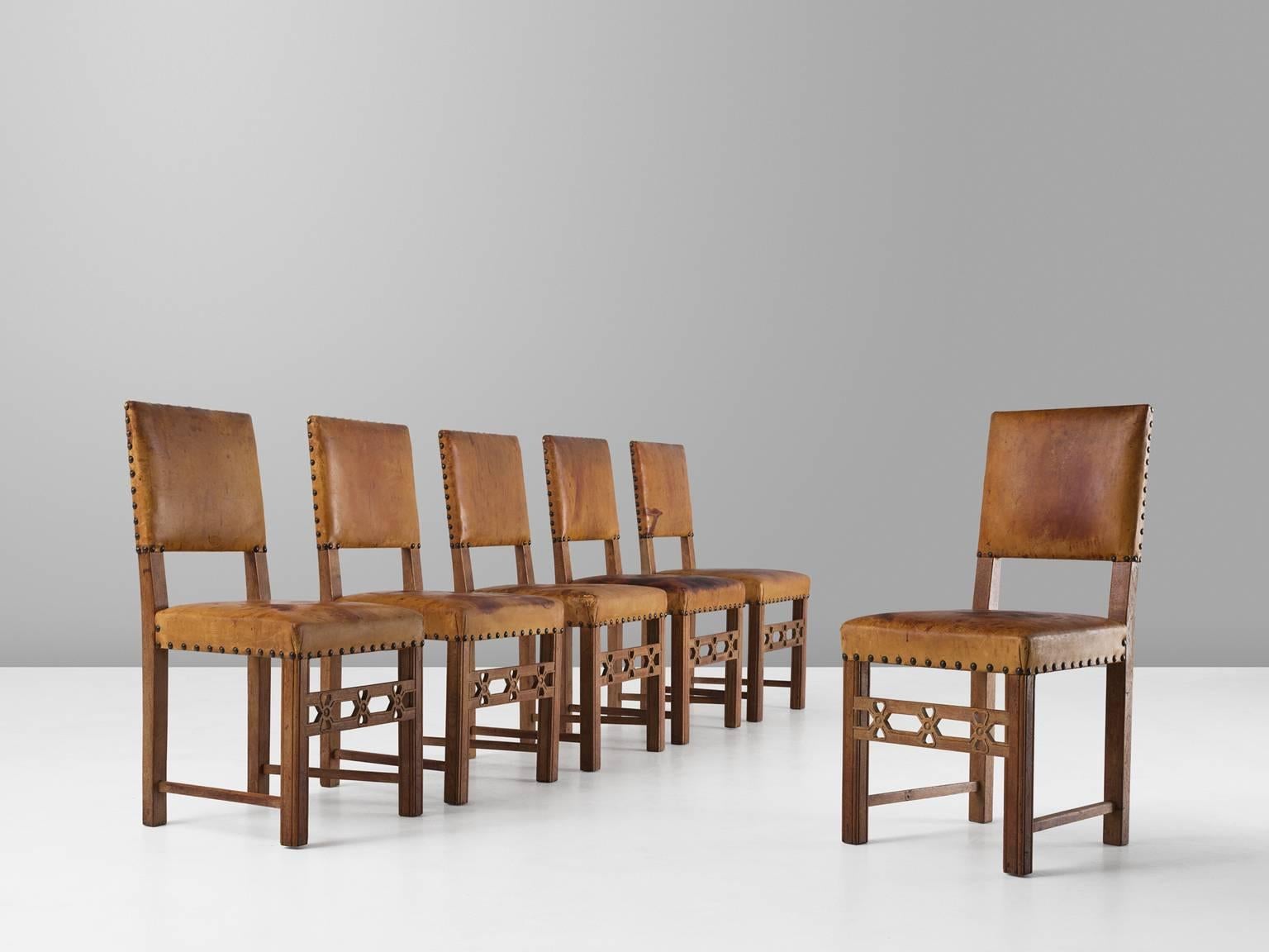 Set of six dining chairs, in oak and leather, Sweden, 1940s.

Set of six elegant dining chairs in oak and expressive patinated cognac leather. These chairs have a straight and simplistic design. Elegant details make these chairs into the unique