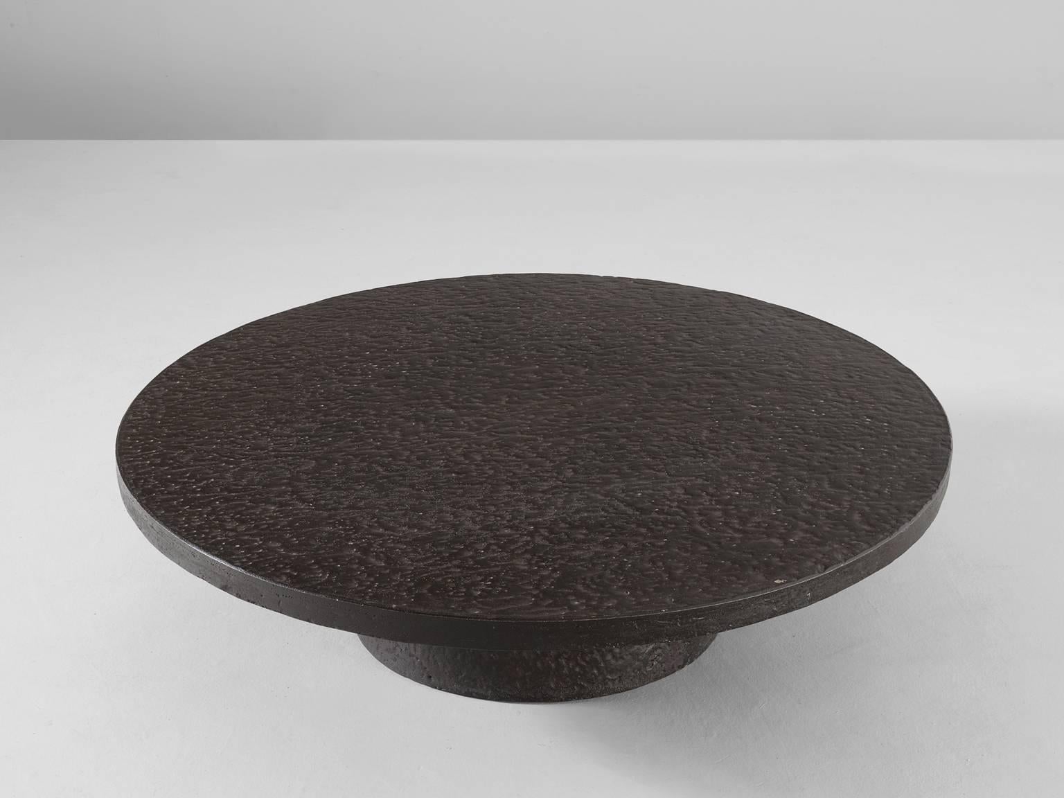 Cocktail table in stone, Europe, 1970s. 

Round coffee table in stone. This table has an interesting appearance, the grey stone or clay looks like cast iron. The round top is supported by a cylindrical base. Excellent table in beautiful color and