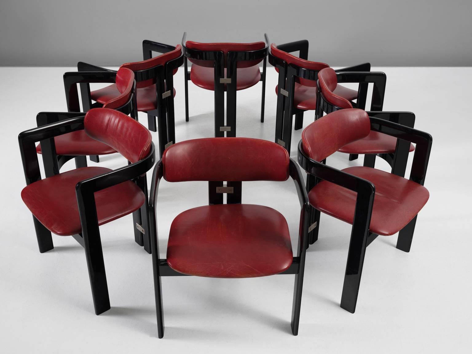 Set of eight 'Pamplona' dining room chairs, in wood and leather by Augusto Savini for Pozzi, Italy, 1965. 

Set of eight armchairs in high gloss black lacquered wood and red leather upholstery. A characteristic design; simplistic yet very strong