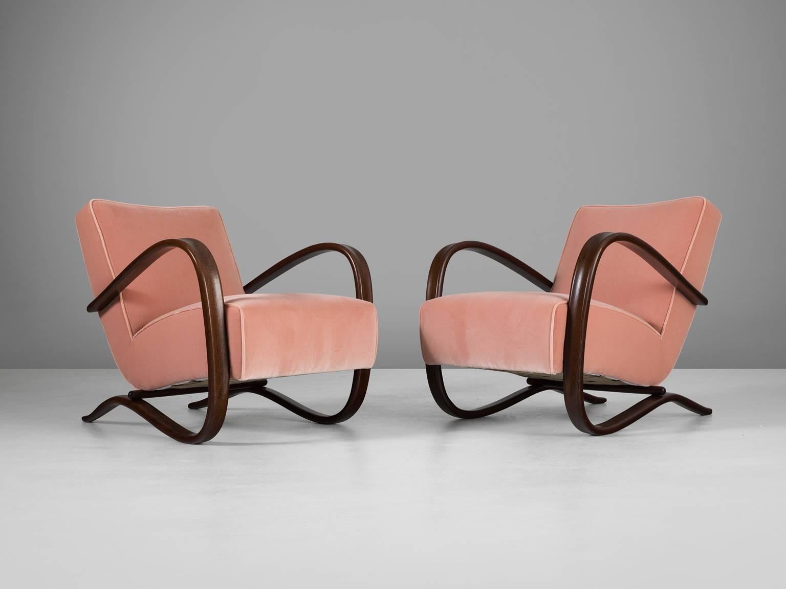 Set of two armchairs, in beech and fabric, by Jindrich Halabala, Czech Republic 1930s.

These chairs have a very dynamic appearance, due the curved base that ends fluently in the armrests. The dark brown stained wood nicely combines to the dark