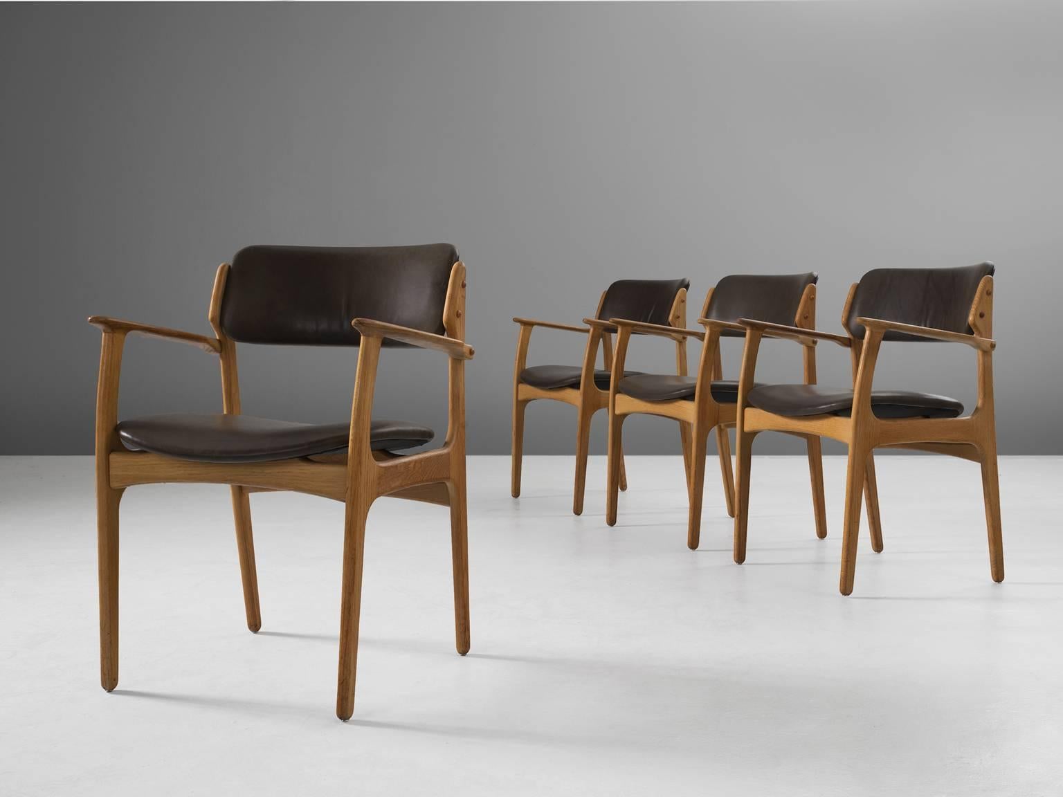 Set of four 'Captains' armchairs, in oak and faux-leather by Erik Buck for Ørum Møbler, Denmark, 1957. 

Set of four dining chairs in solid oak. These chairs show the characteristics of the well-known model 50 by Erik Buck (1923-1982). They have a