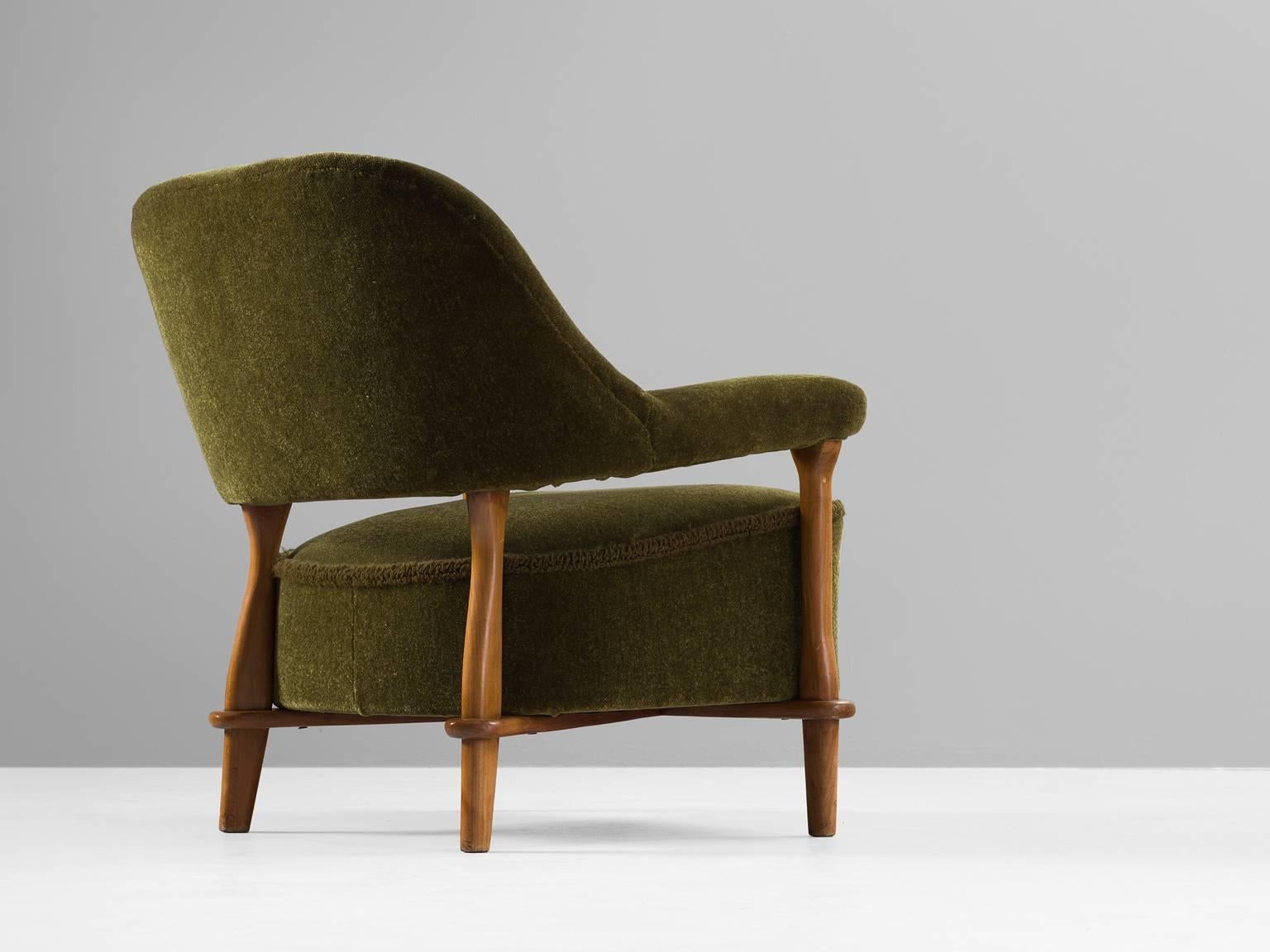 Armchair, velvet and oak, 1950s.

This moss green voluptuous armchair by Theo Ruth (1915-) is a very strong singular item. The back flows with a natural grace into the armrest. The open gap between the backrest and the seating gives the chair a