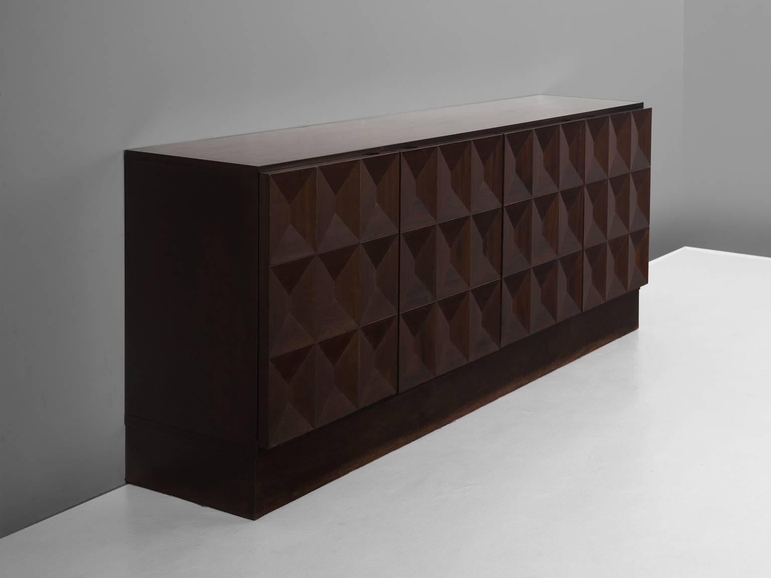 Sideboard, in oak, European, 1970s. 

Large Brutalist credenza in oak veneer with graphic designed door panels. Four doors, each with a three-dimensional pattern of squares. Each square has an inward pyramid figure, which gives this cabinet a very
