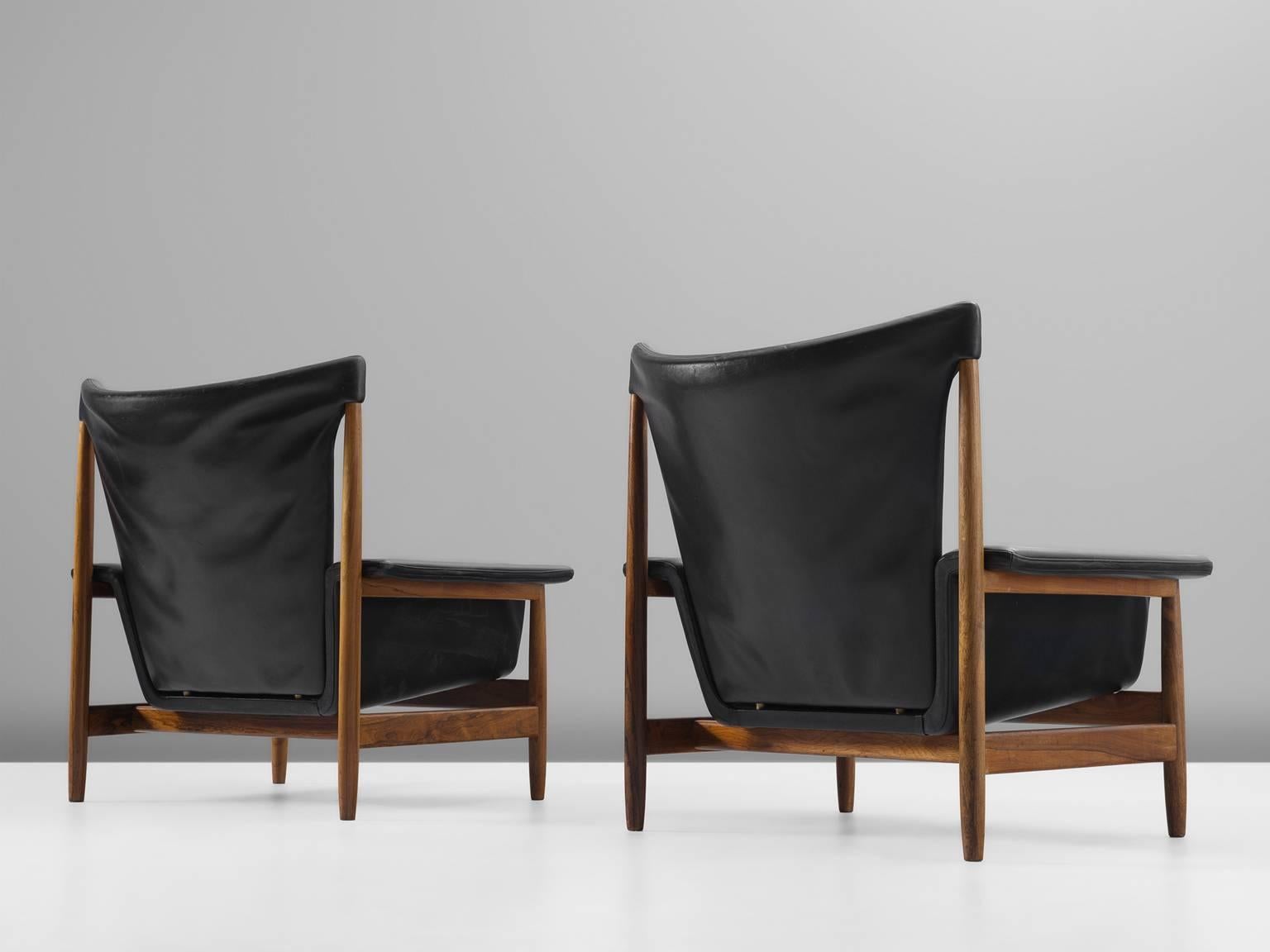 Lounge chair in rosewood and leather, Scandinavia, 1960s. 

This pair of comfortable and stately lounge chairs are executed in original and high-quality black leather. The chairs are mode of solid rosewood and the weight is accordingly. The