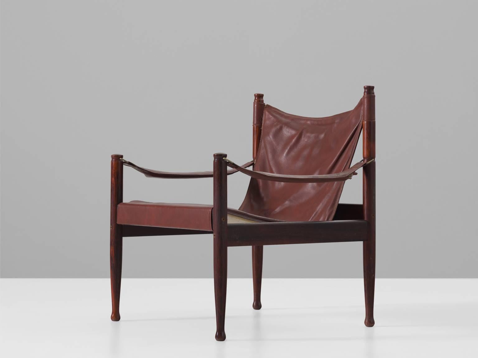 Erik Wørts safari lounge chair in rosewood and brown leather, Denmark, 1950s.

Fantastic lounge chair in a deep red, brown or rusty colored leather. This chair is very dynamic due it's design and shapes. The soft leather armrests complement the