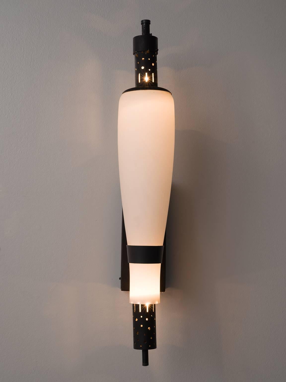 Art Deco wall lights, steel and opaline glass, France, 1940s. 

These delicate tapered wall lights are the perfect middle between ornate and simplistic. The opaline glass has a pure form whereas the base and top are punctured in order to let the