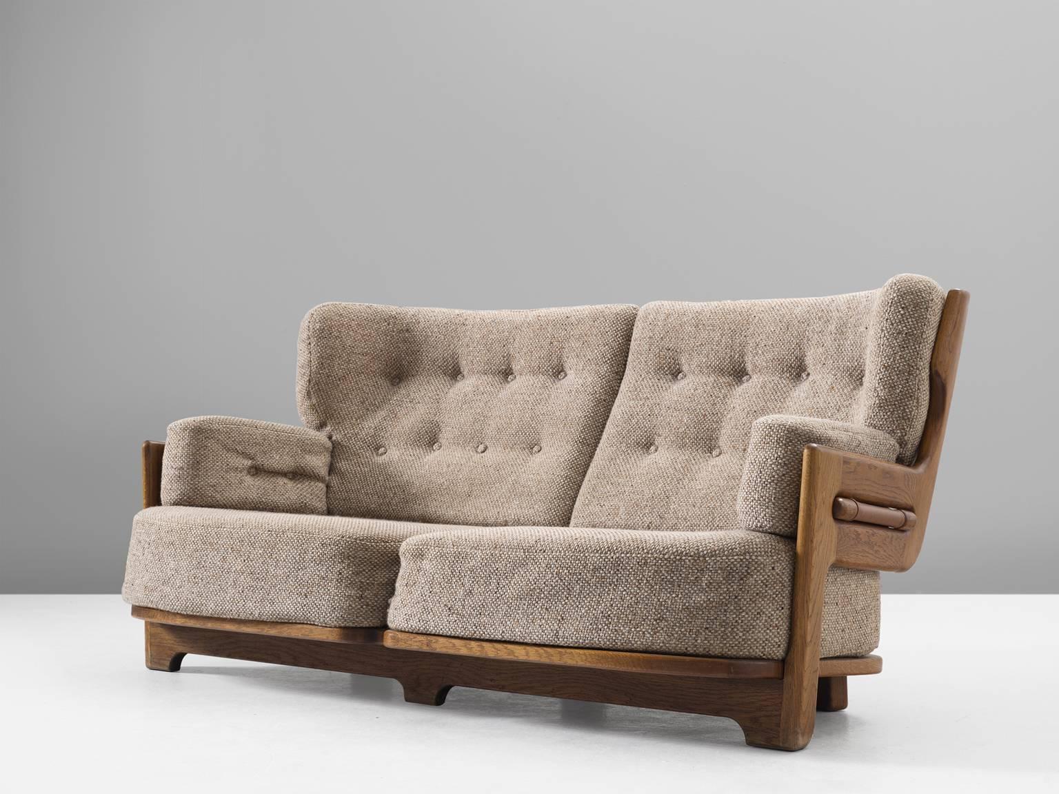 Sofa, in oak and fabric, by Guillerme et Chambron, France, 1960s. 

Extraordinary sofa by Guillerme and Chambron, in solid oak with the typical characteristic decorative details at the back and capricious forms of the legs. Very comfortable, great