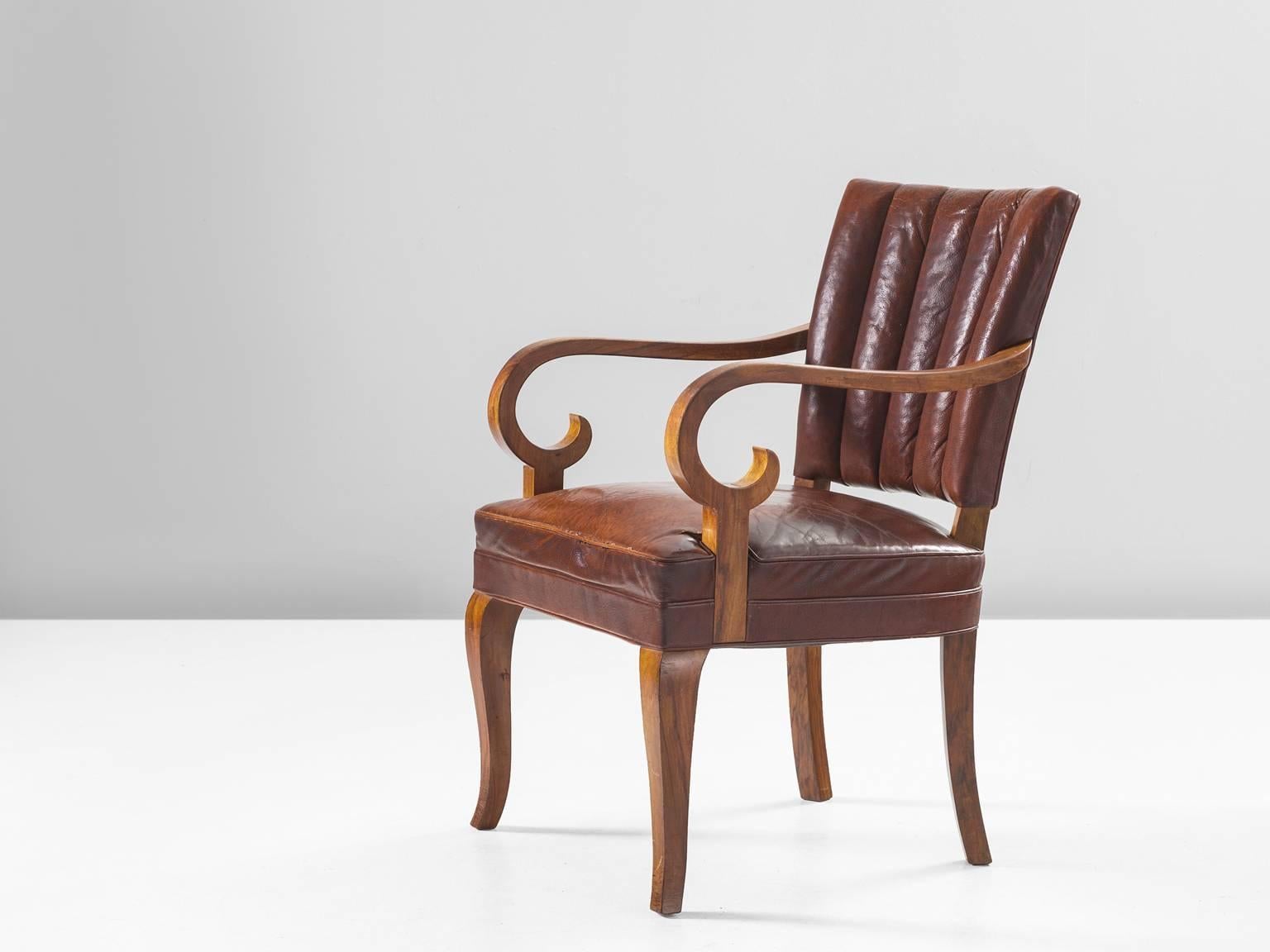 Armchair, leather and walnut, Denmark, 1940s.

This dining chair has incredible sensuous details. Take a look at the swirling armrests or the tapered and curved legs. The lines in the chair are very sharp whereas the forms in themselves are organic.